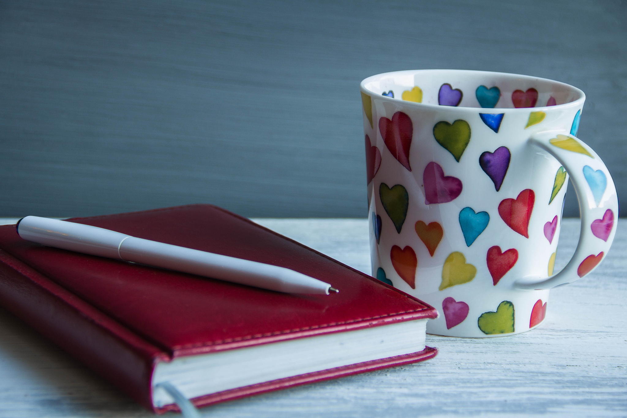 Warm Lighting, Books, Flowers, and Business-Themed Paper Cups on a Table