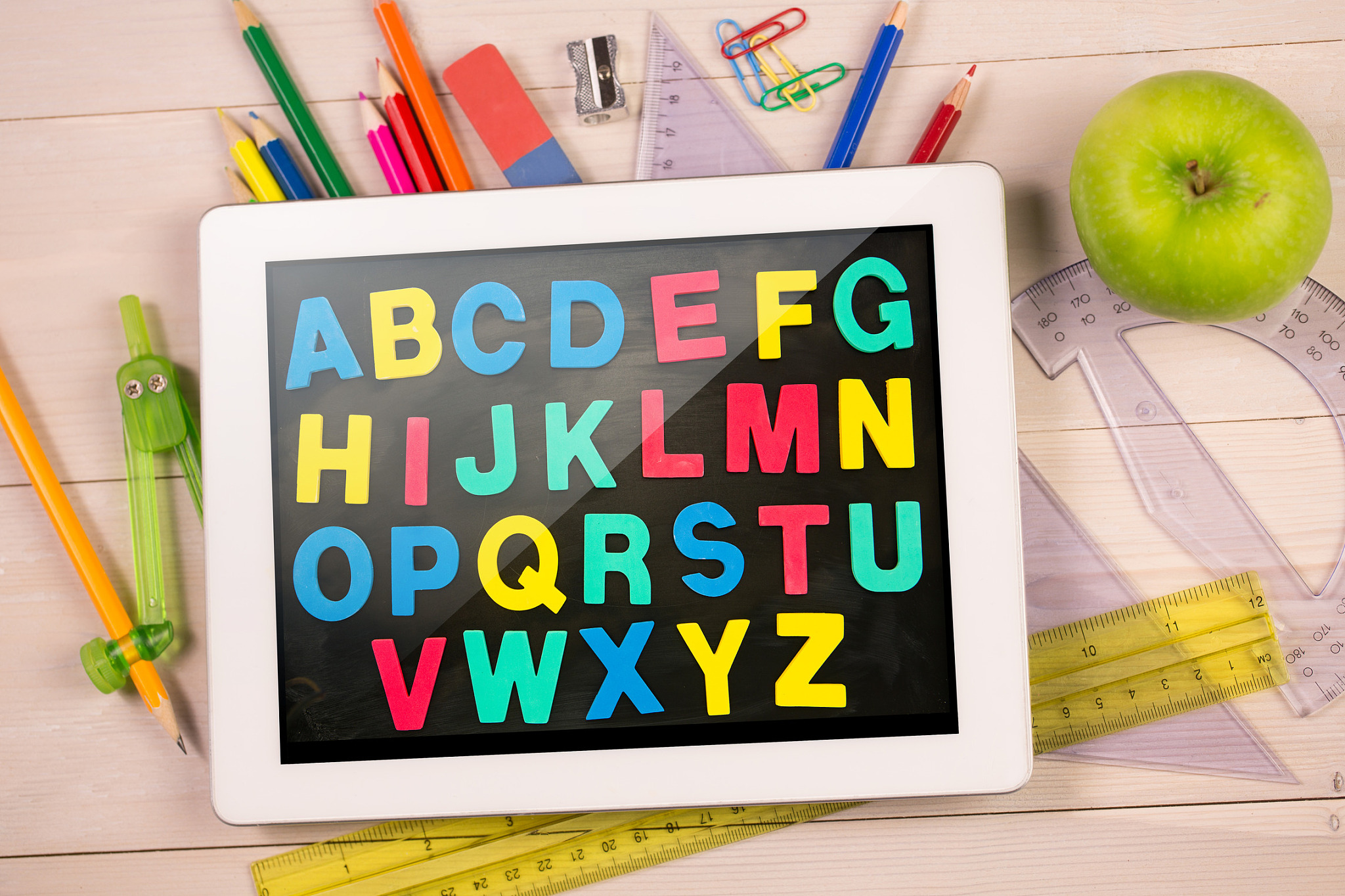 composite image of digital tablet on students desk showing alpha