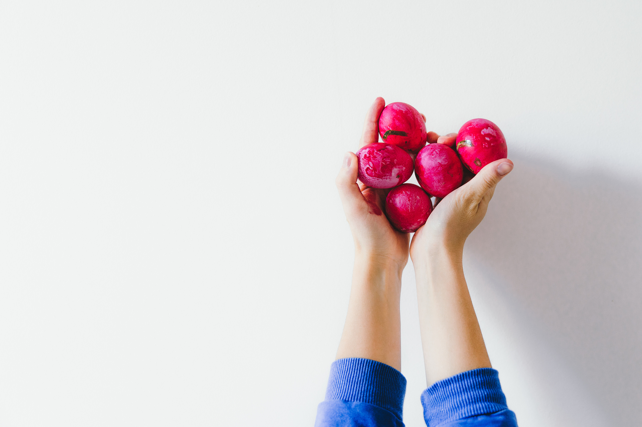 woman holding pink painted easter eggs in her hands