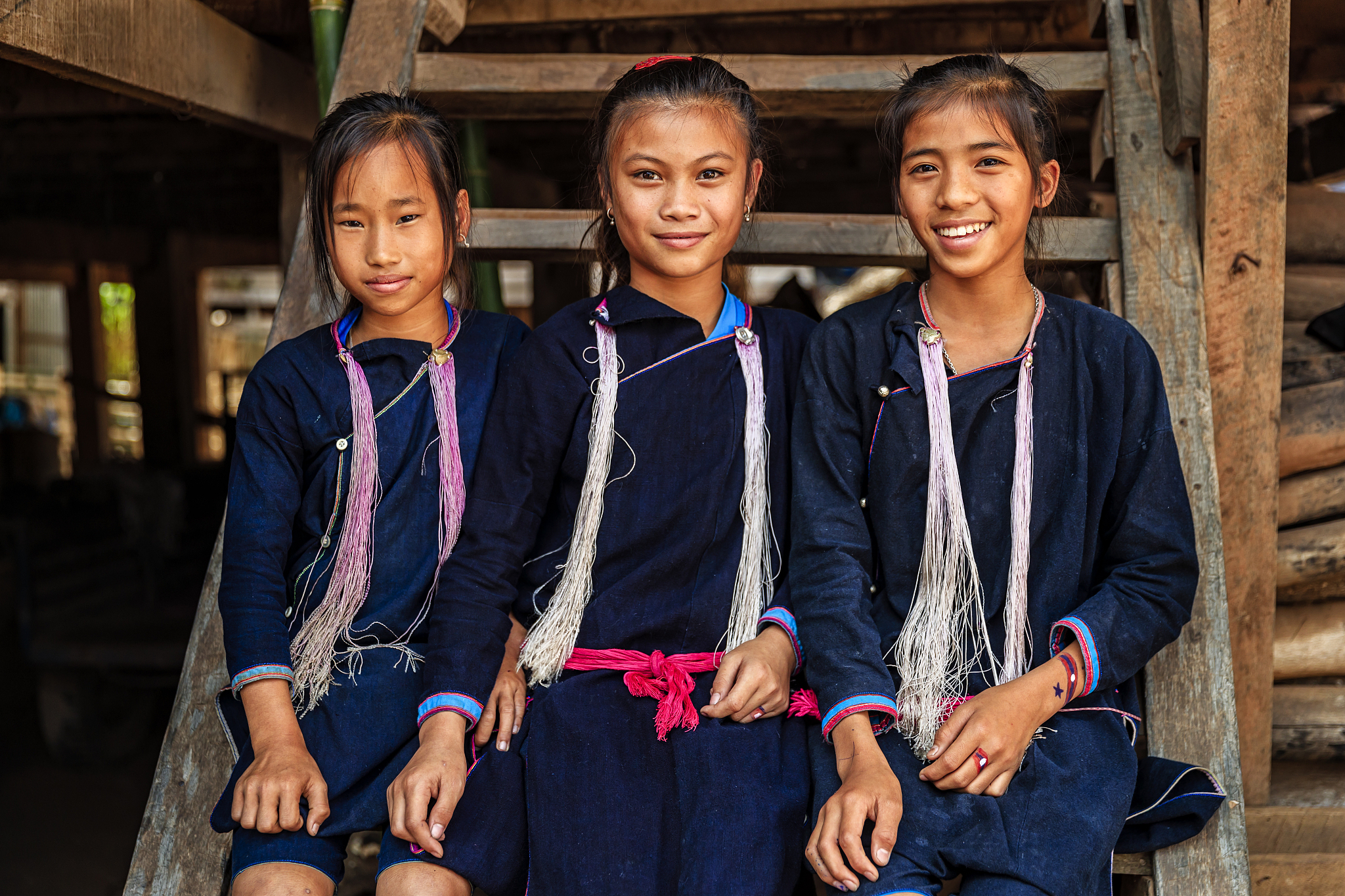three laotian young girls in a village in northern laos