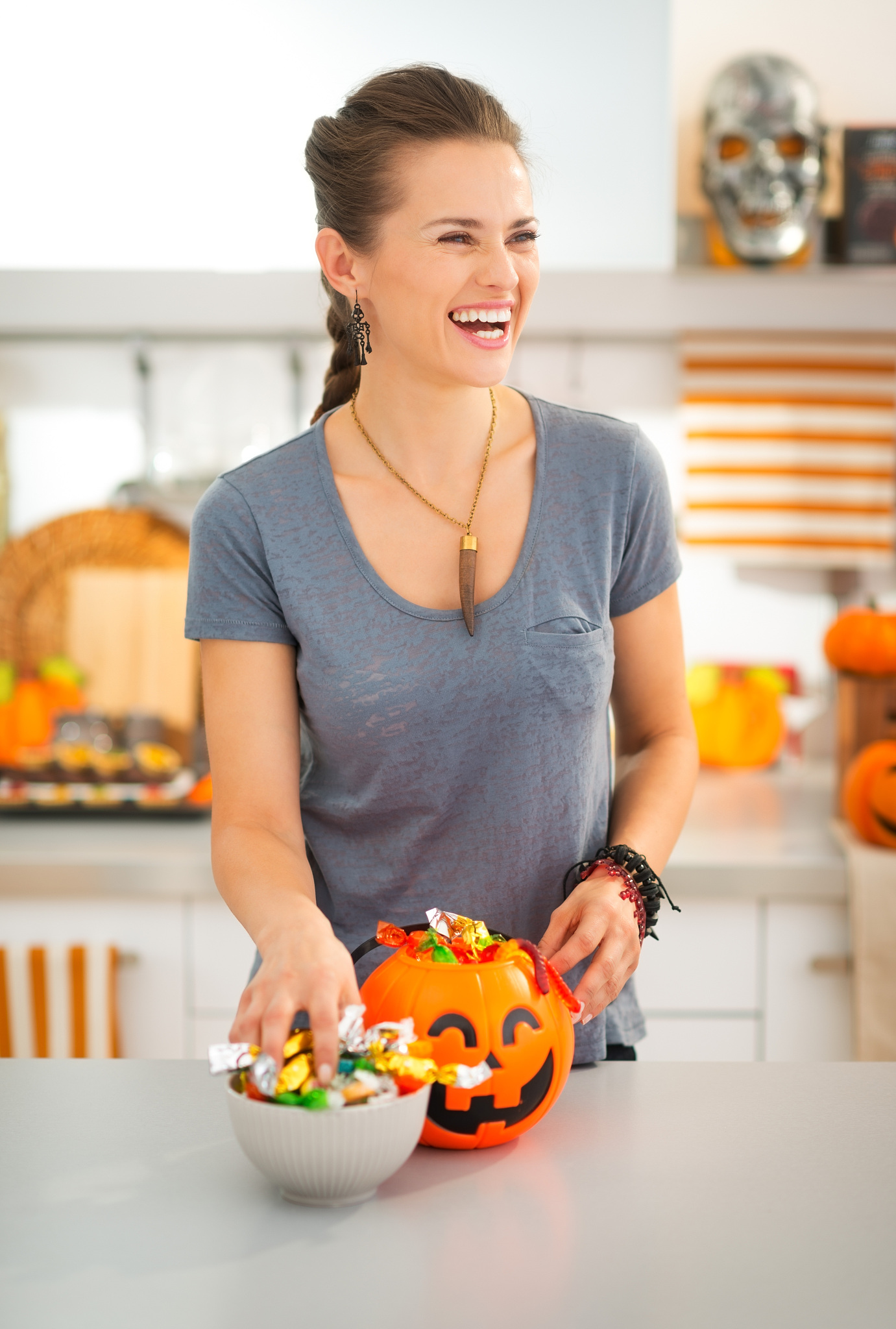 laughing woman preparing halloween trick or treat candy for kids