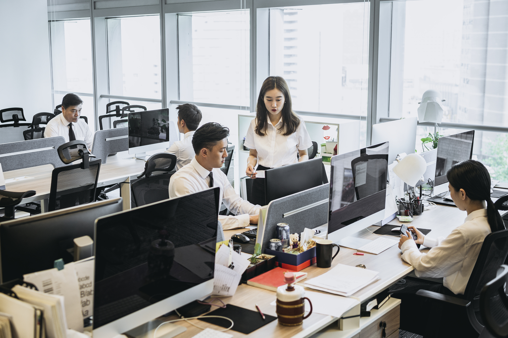 chinese media industry workers seated at computer monitors