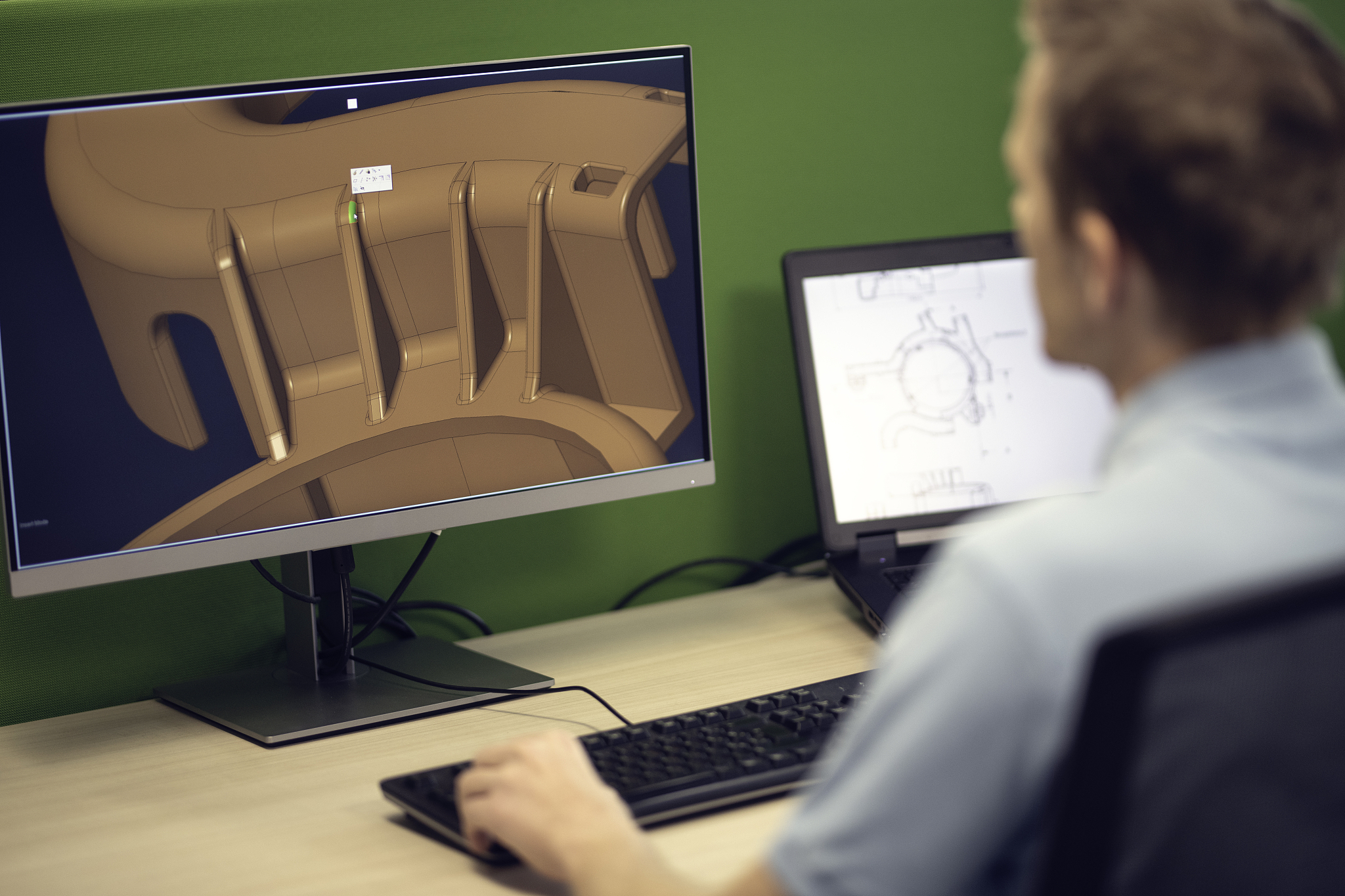 engineer using a computer to make a 3d model of a machine part