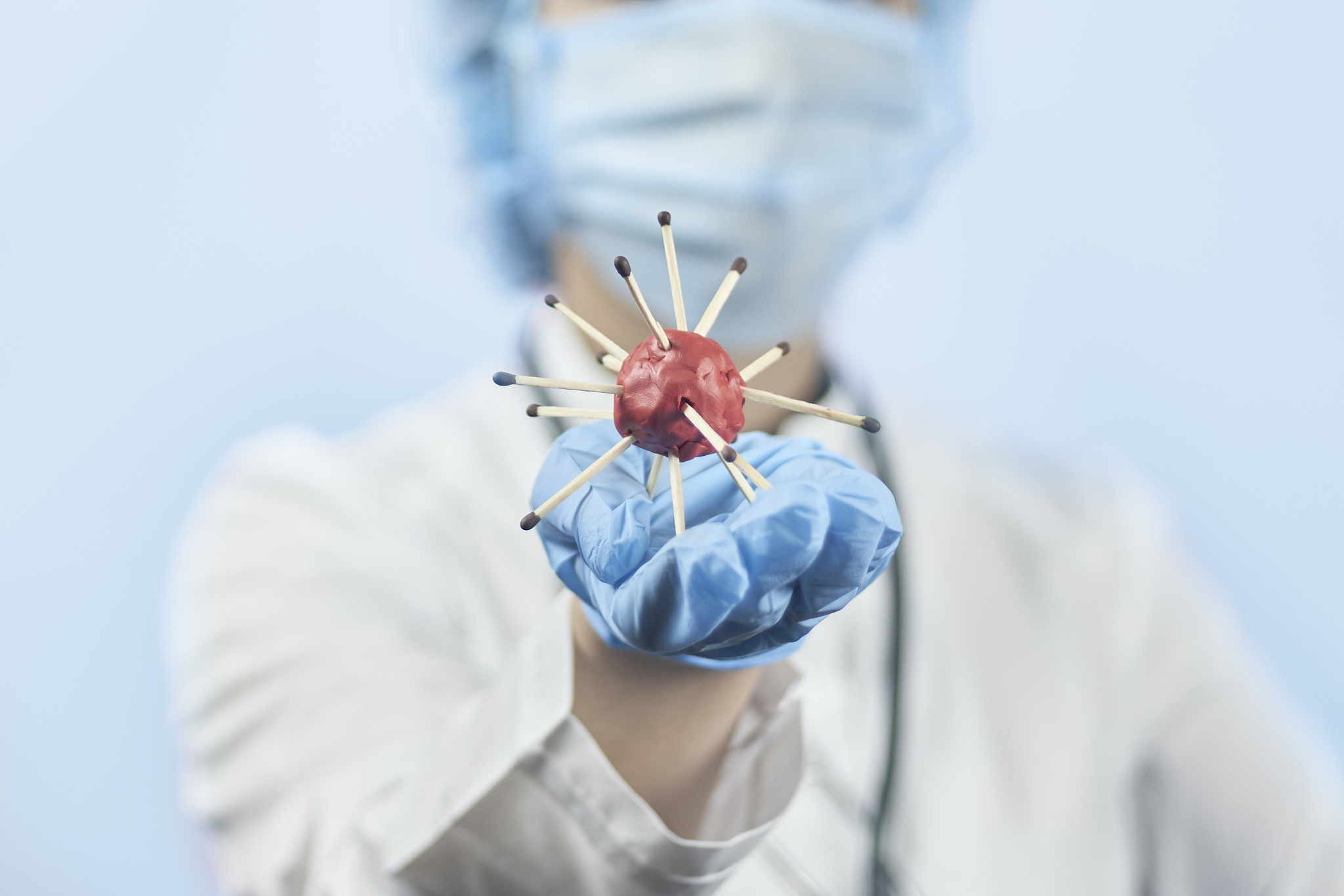 female doctor in protective medical uniform holding coronavirus