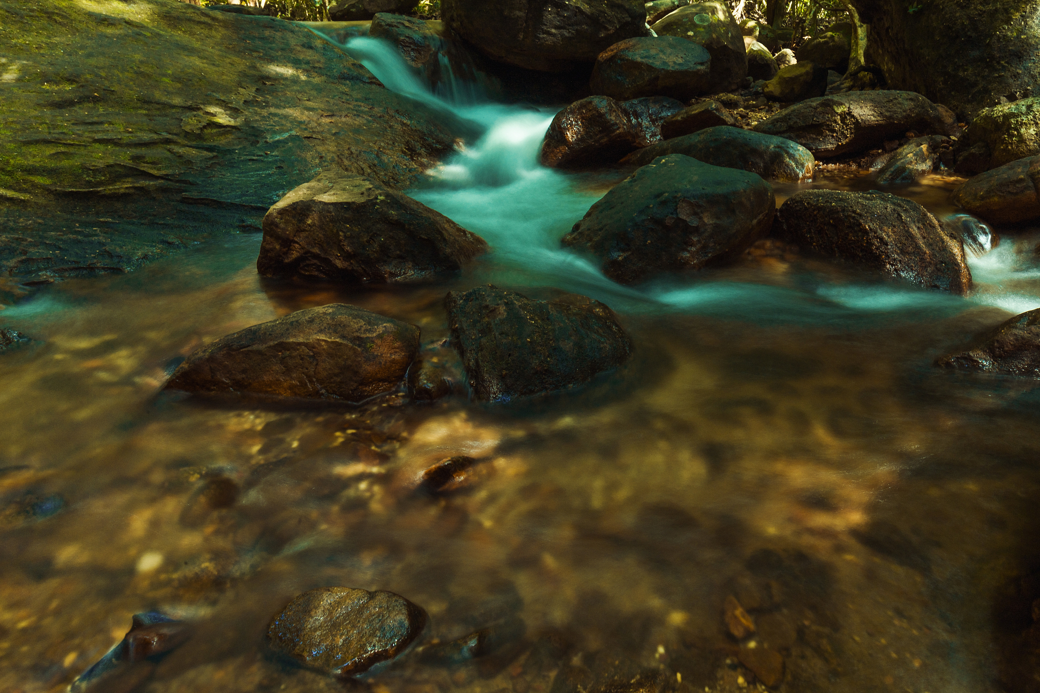 close-up of water flowing through pebbles in stream