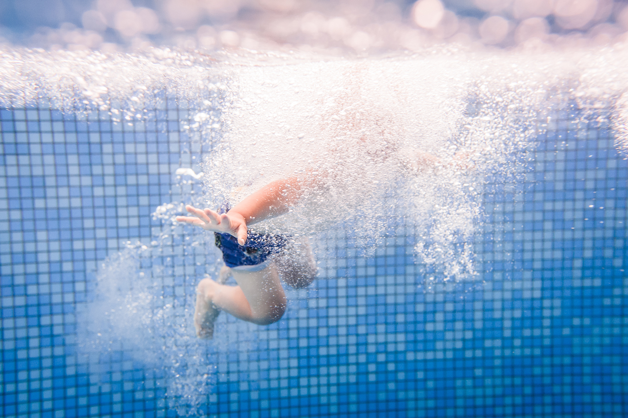 little baby, boy swimming under water in paddling pool. diving b
