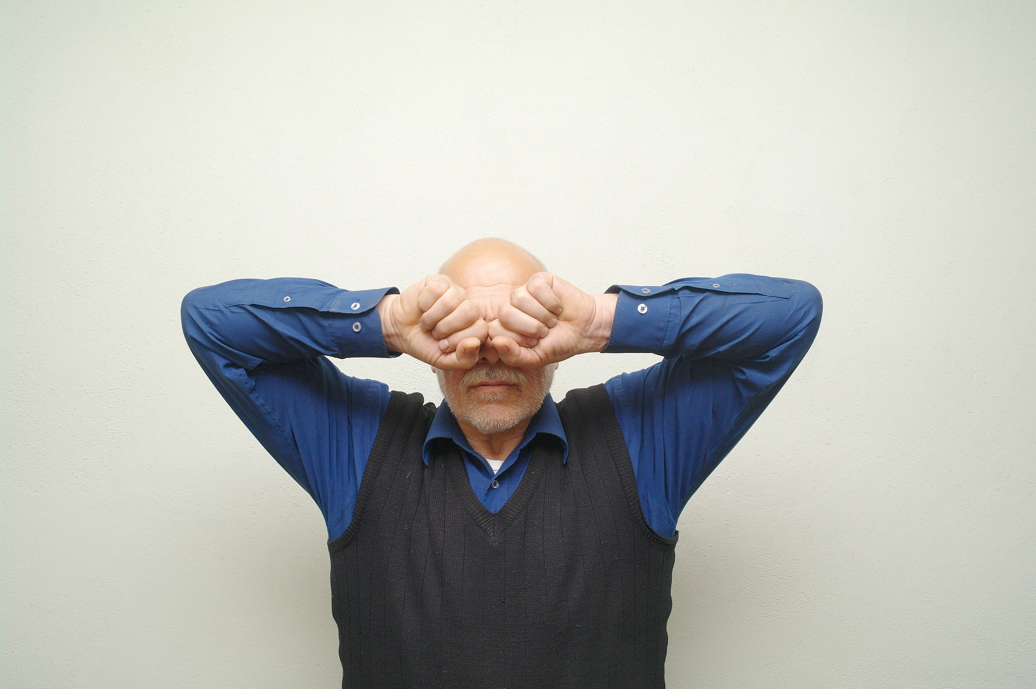 man stands and closes his eyes with hands