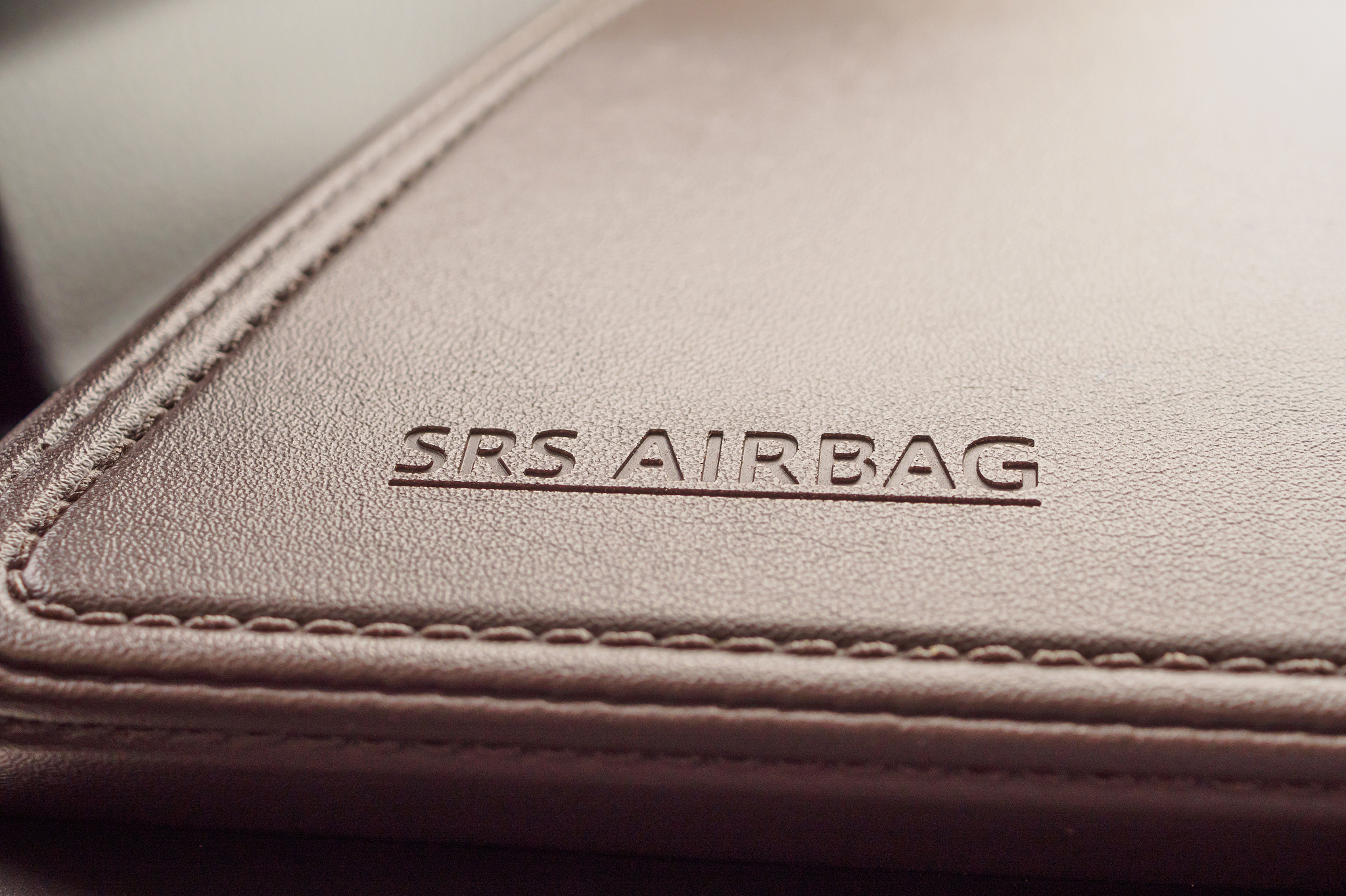 airbag safety sign on brown leather texture in modern car