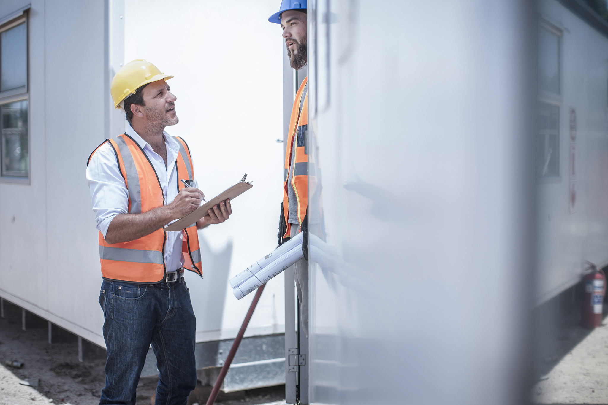 construction worker talking to foreman from doorway of construct