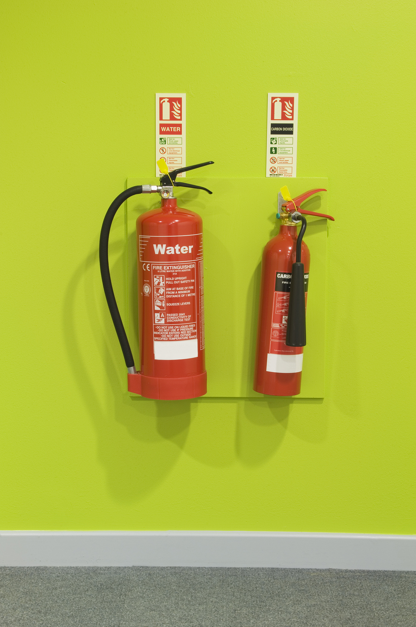 red fire extinguishers on a green wall