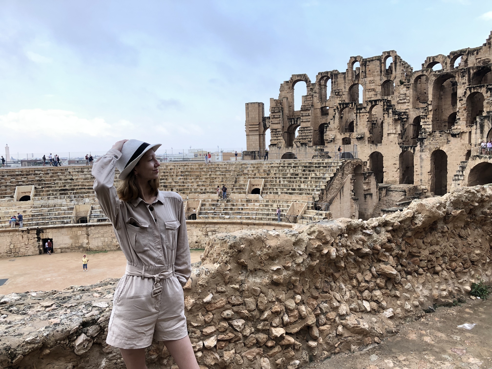 woman wearing hat standing against historical building