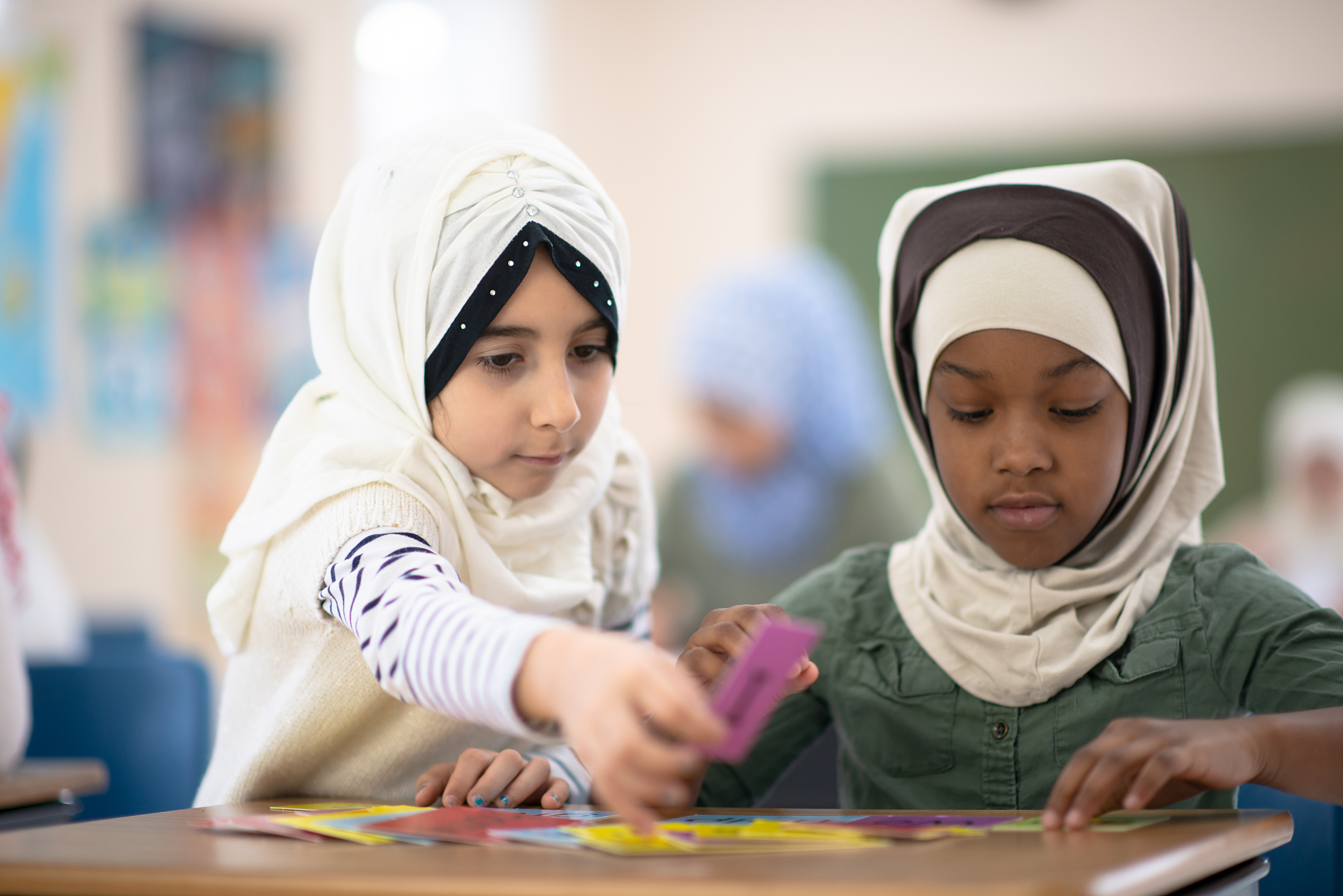 two muslin students working together at a desk stock photo