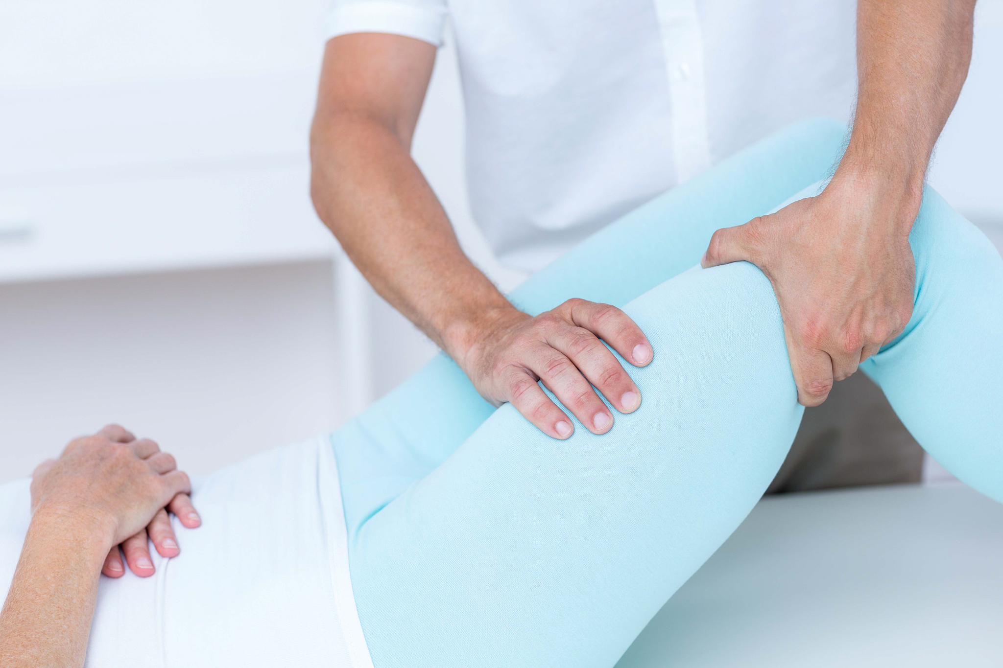 physiotherapist doing leg massage to his patient in medical offi