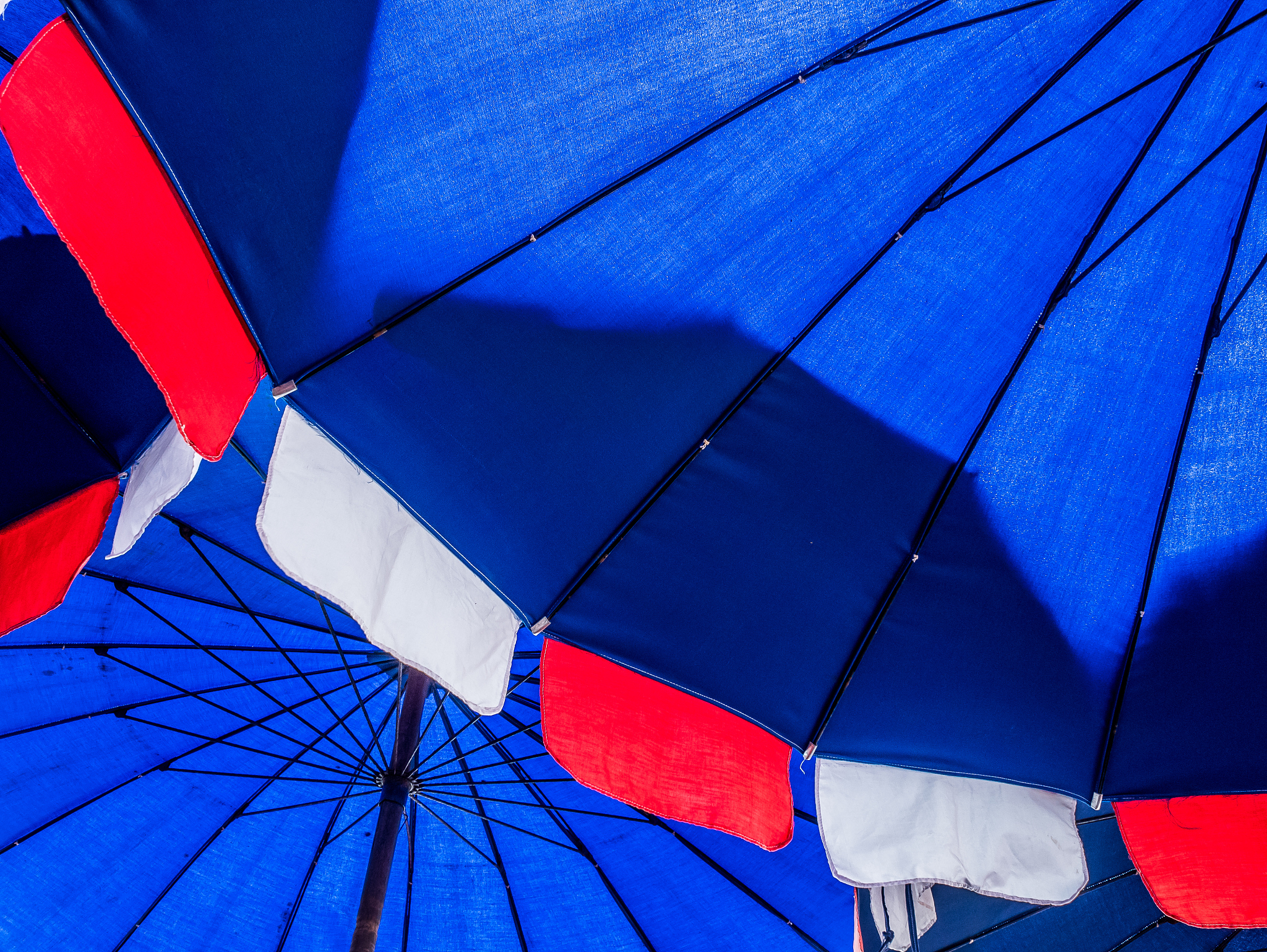 under big blue umbella on the beach safety from uv.