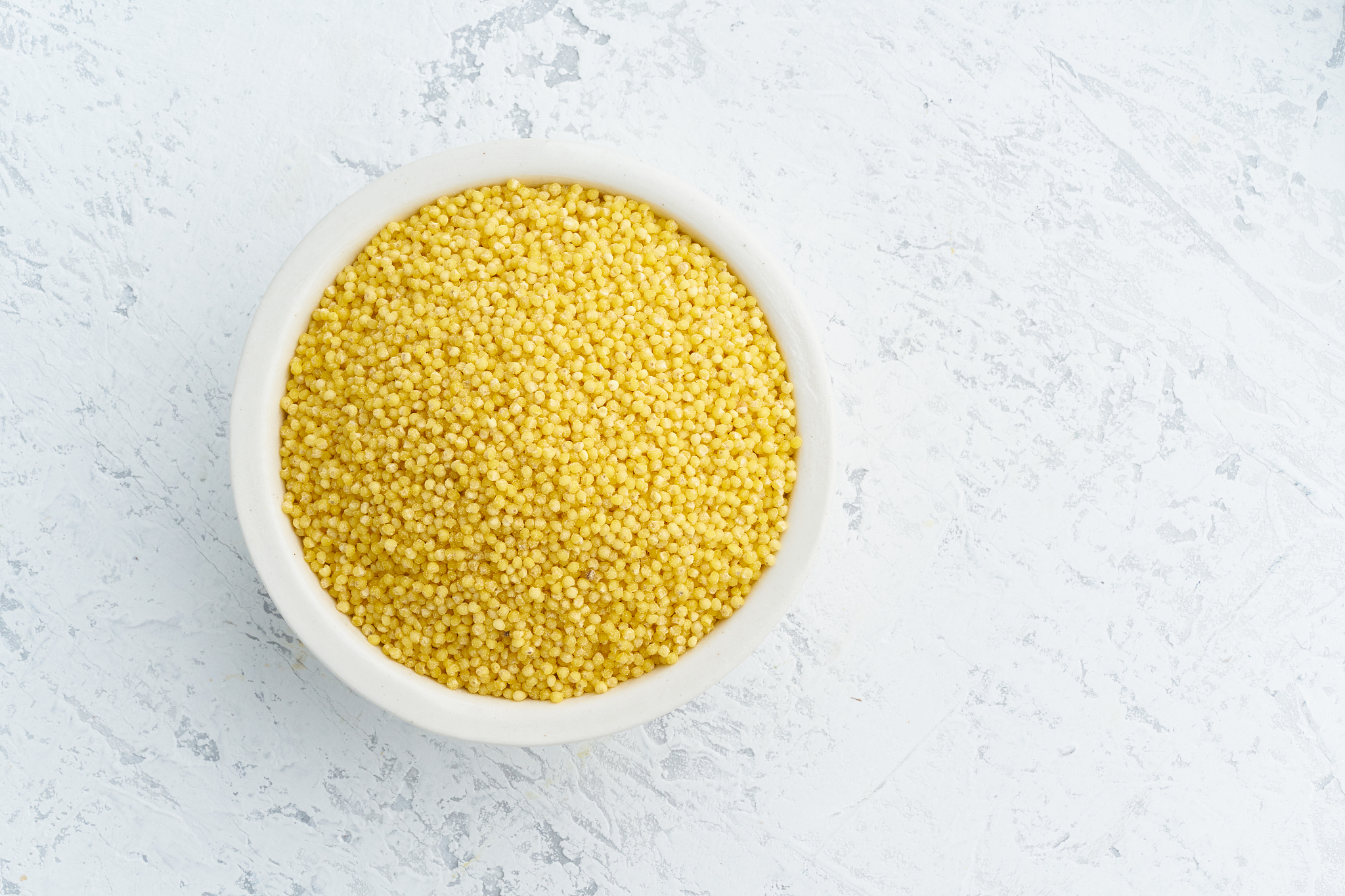 millet, bulrush in white bowl on white background. lectine free,