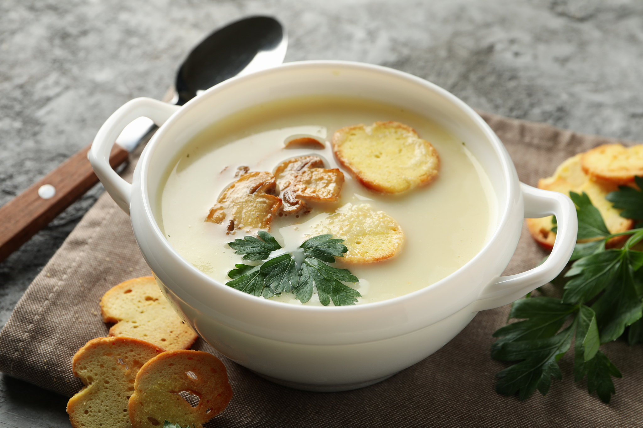 concept of tasty lunch with bowl of mushroom soup on gray backgr