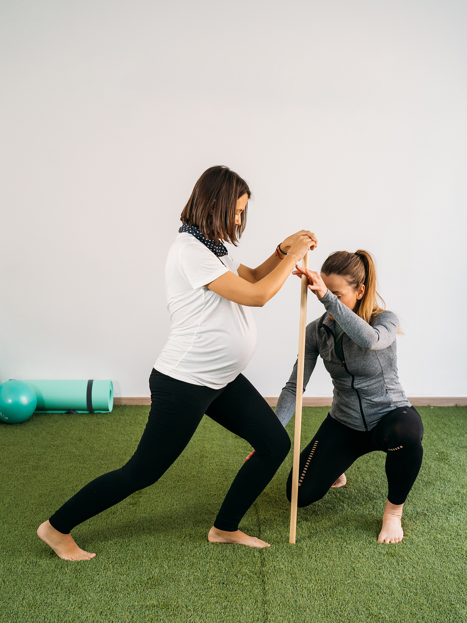 pregnant woman doing fitness ball and pilates exercise with coac