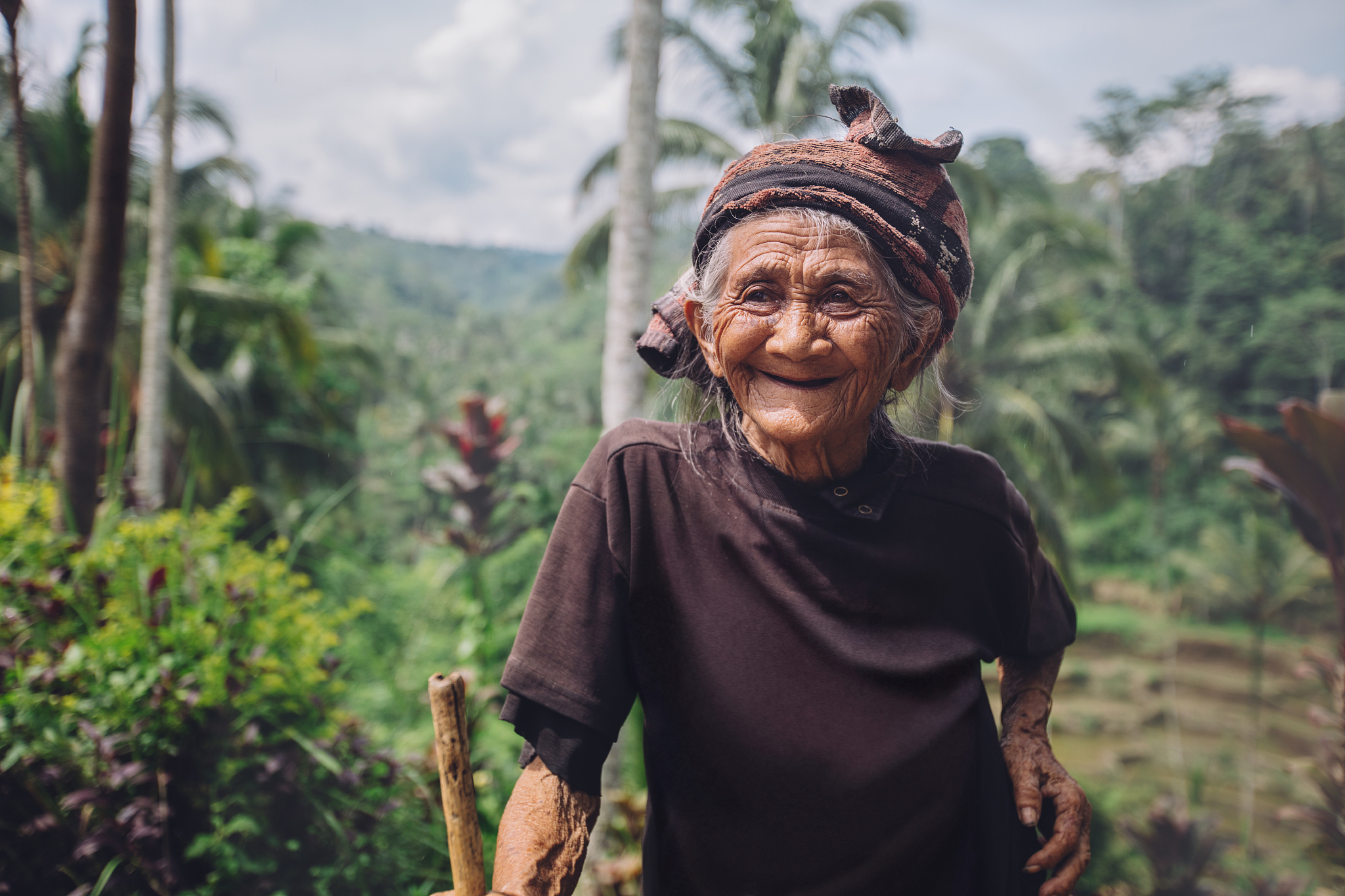 happy senior woman with a cane in village