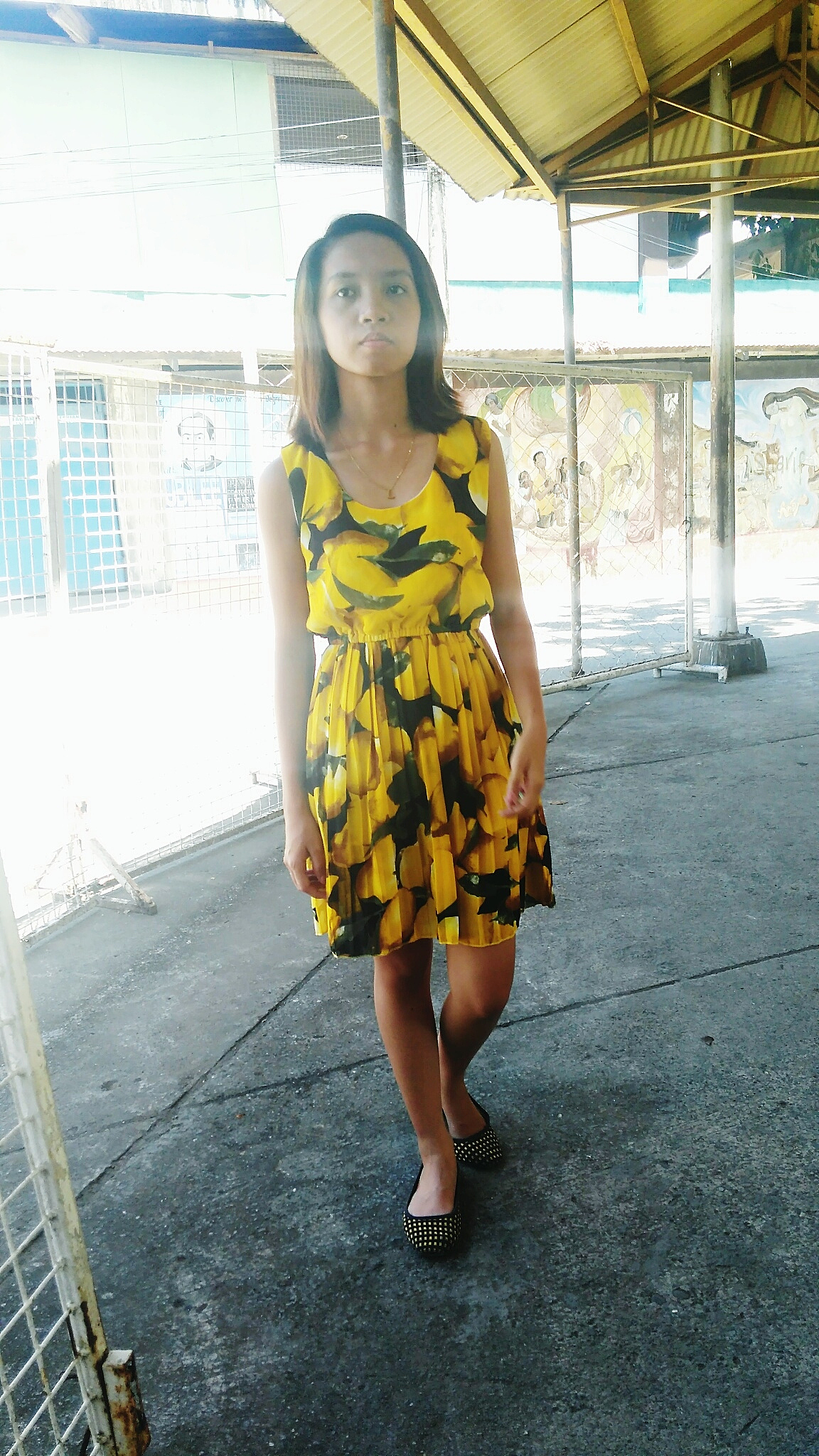 full length portrait of young woman standing on footpath