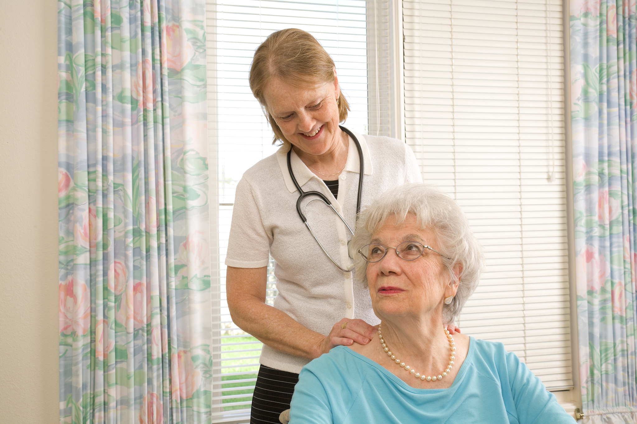 massage physical therapist attends to senior woman, home healthc
