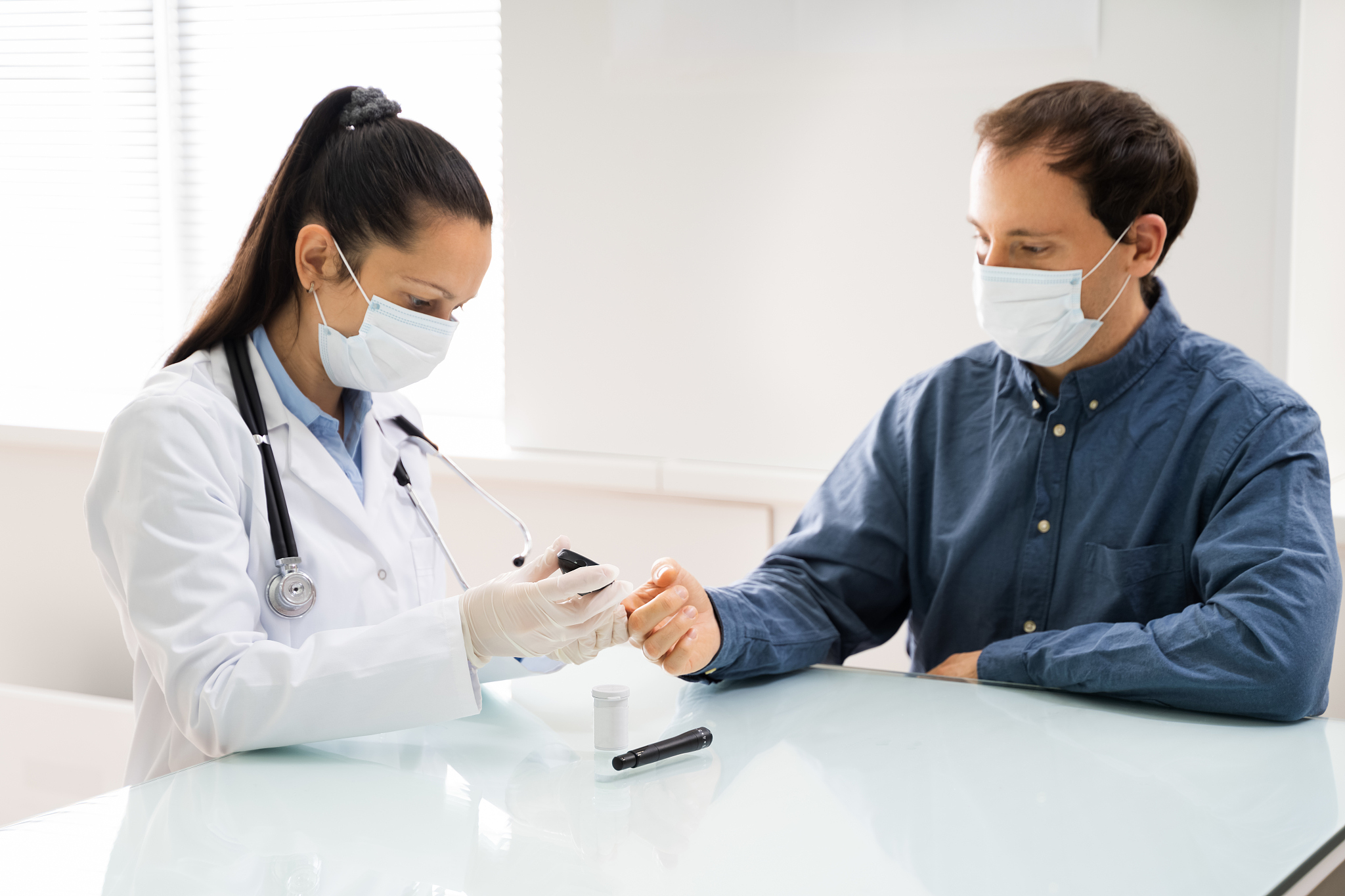 doctor in face mask checking blood glucose
