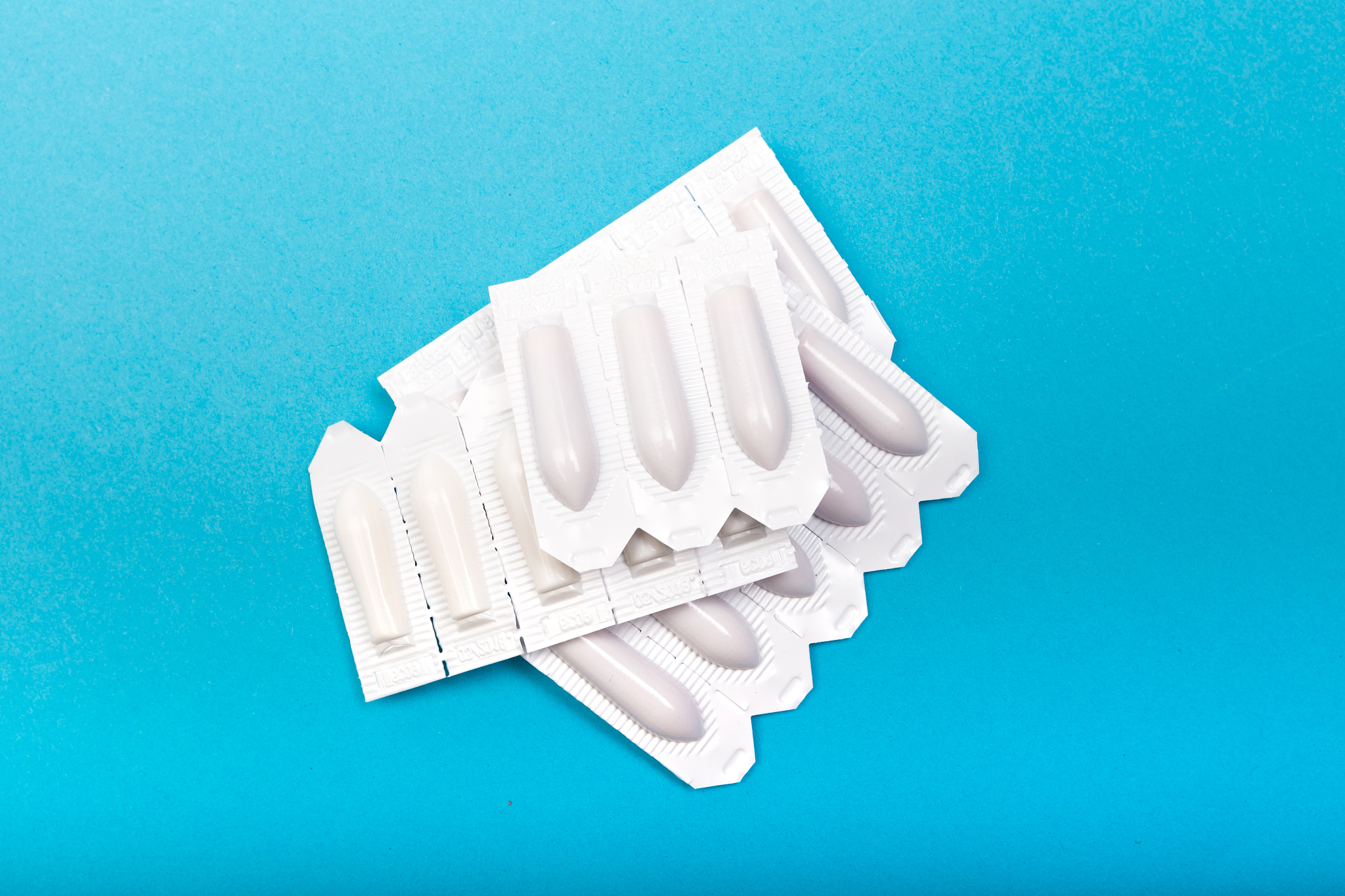 plastic packs of suppositories on blue  background - image