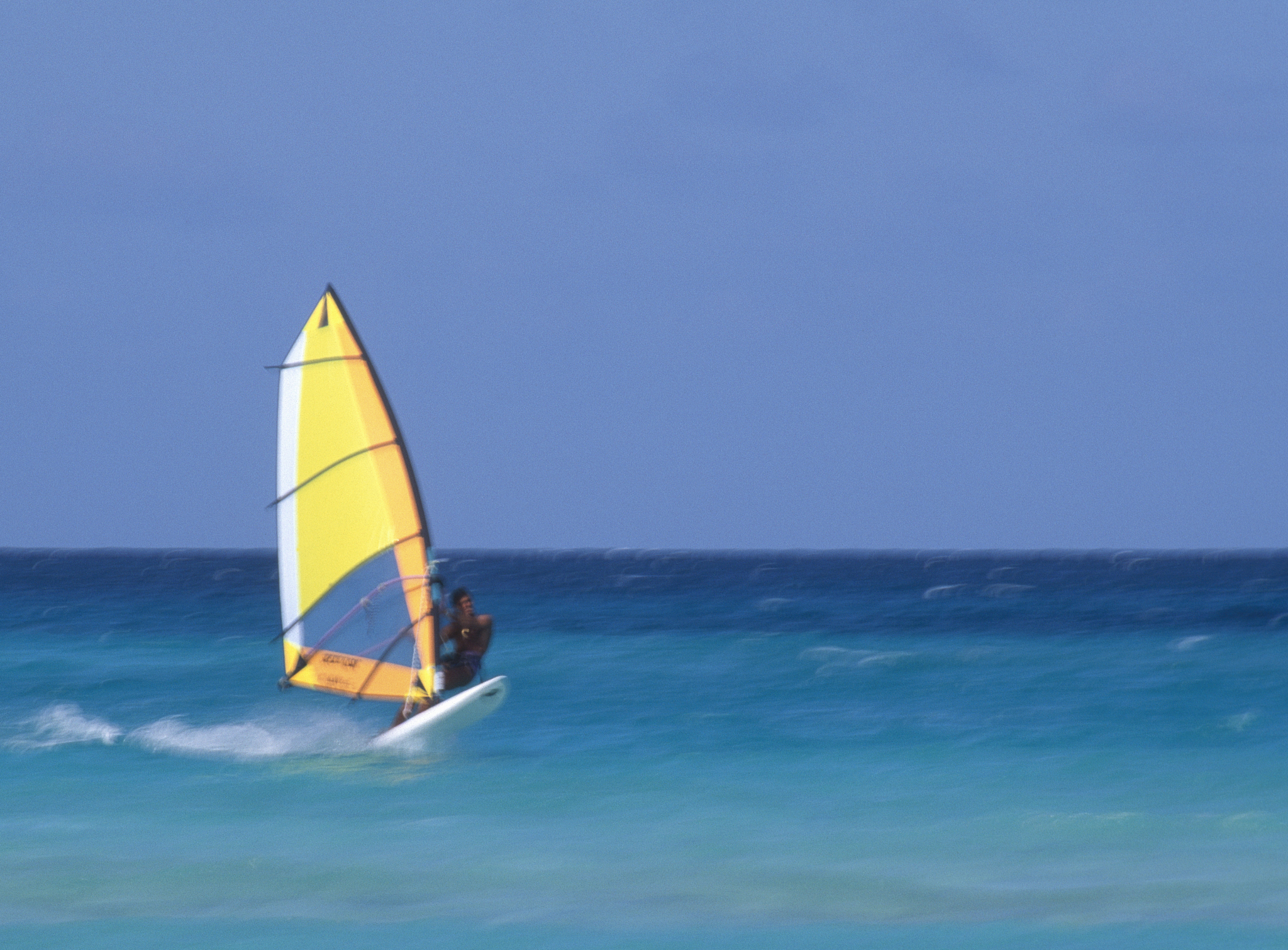 windsurfer speeding on blue sea