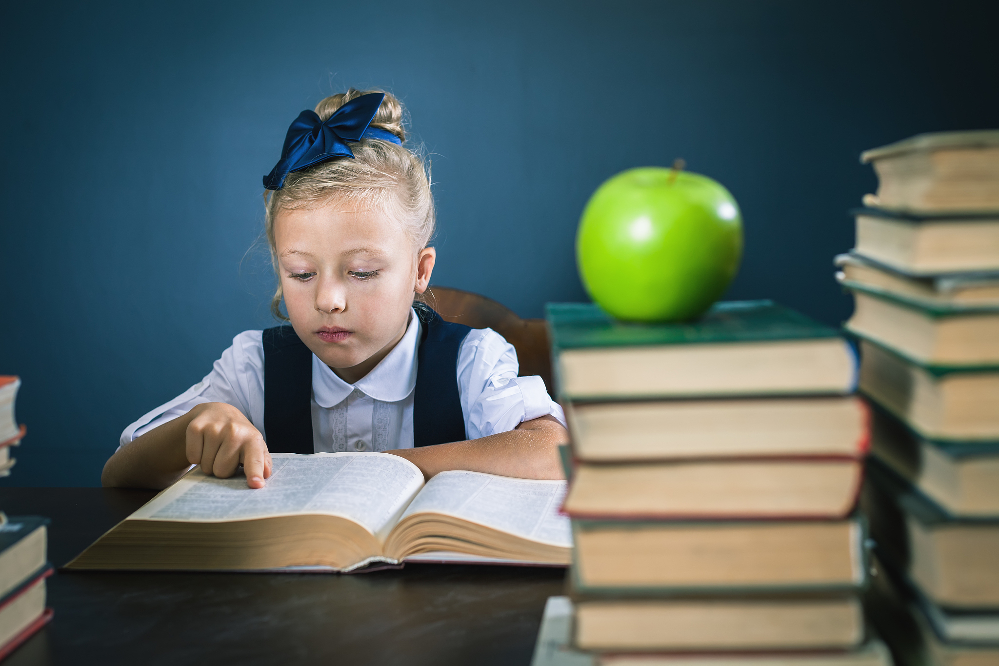 smart school girl reading a book at library