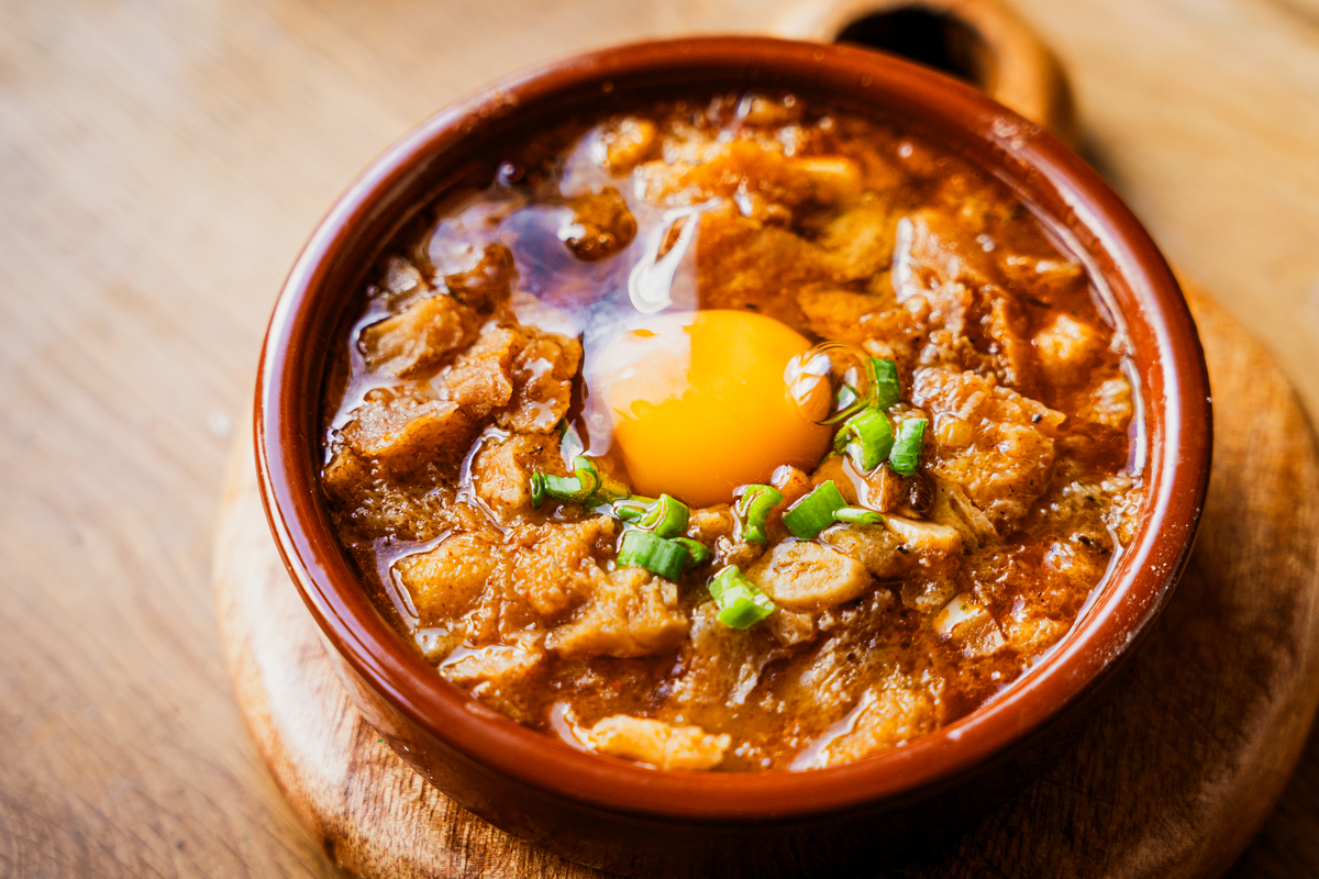 特写西班牙大蒜汤"sopa de ajo",配有鸡蛋,木桌上的