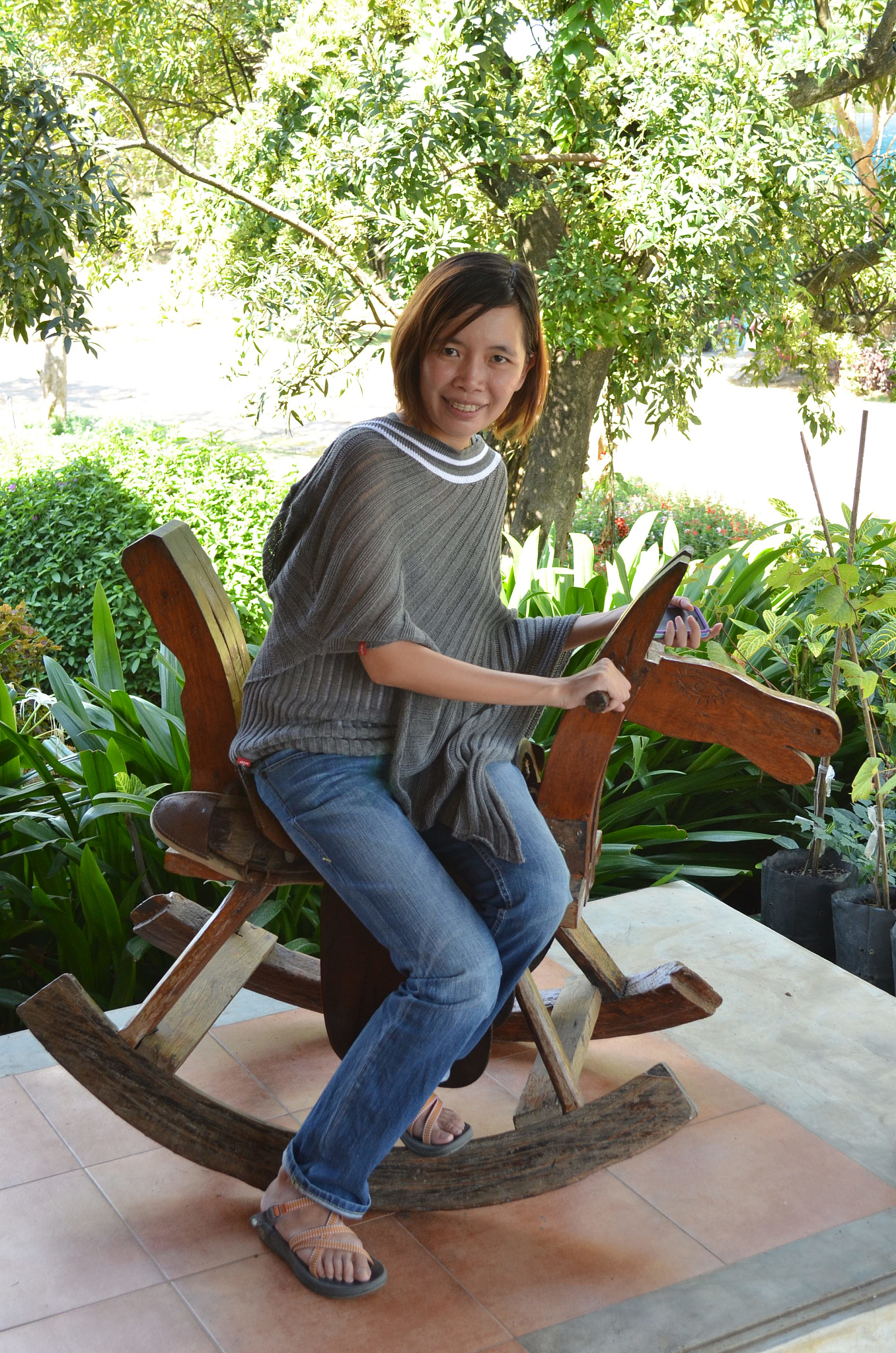 portrait of smiling woman sitting on rocking horse