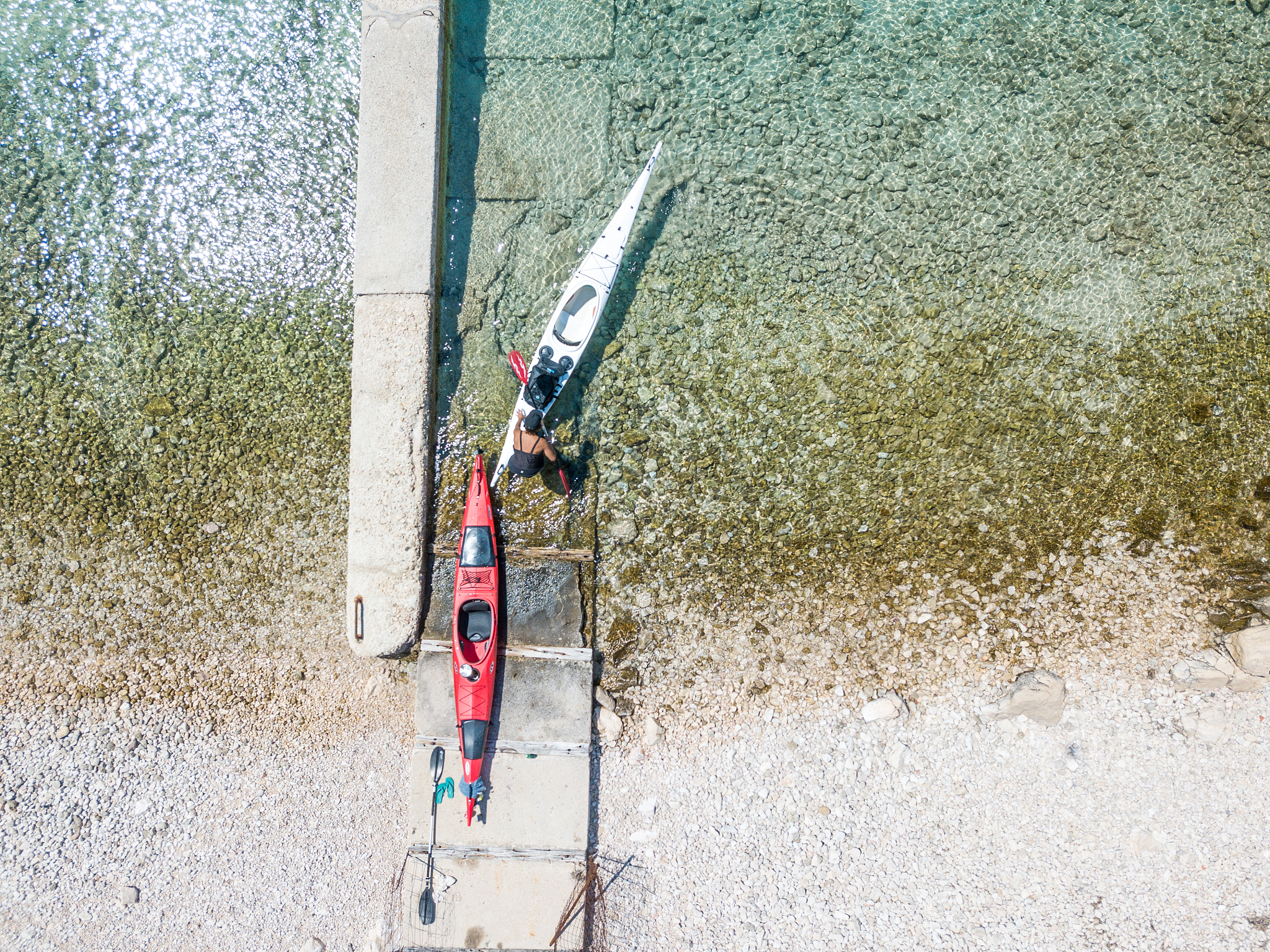 man pulling a kayak out of water