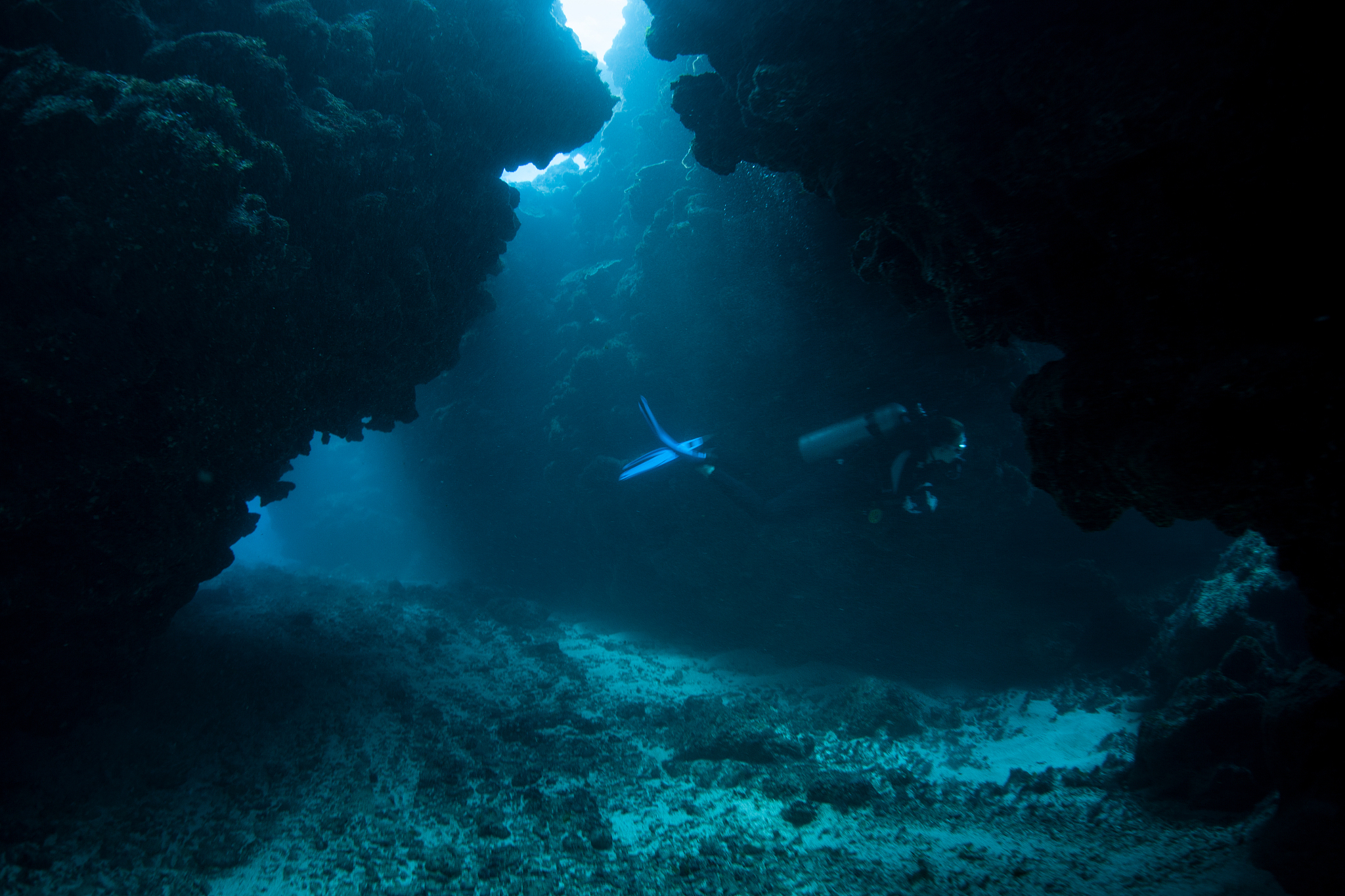 divers in dark underwater grotto