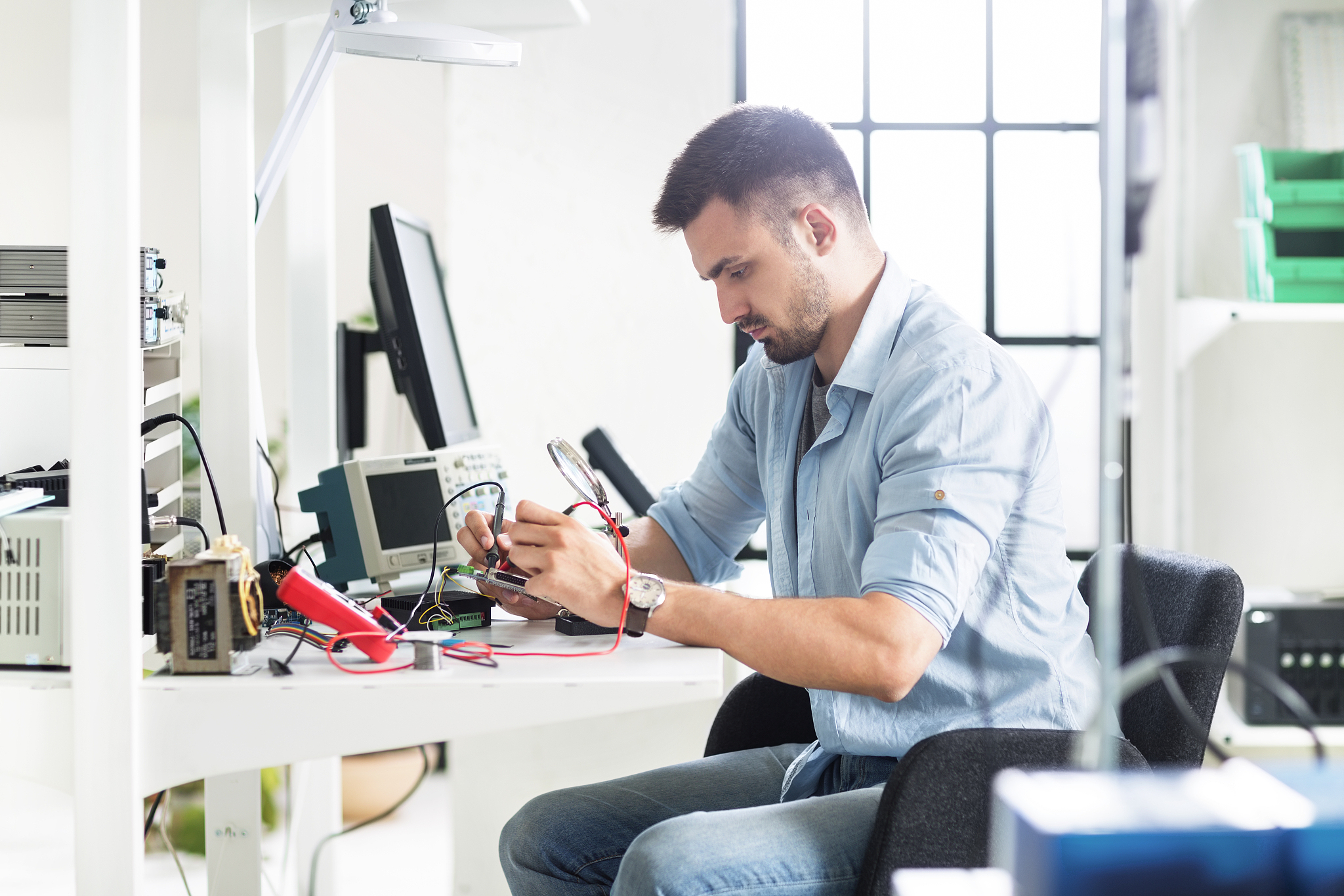 serious engineer working at table in electronics laboratory