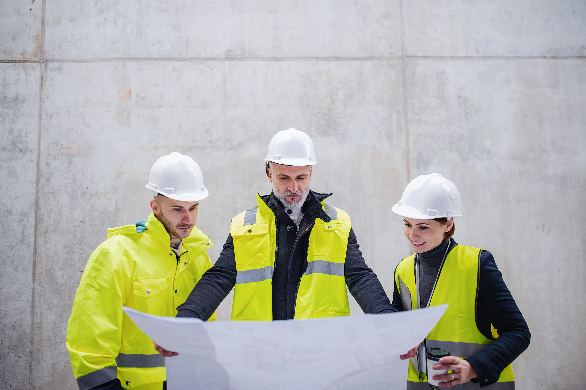a group of engineers standing against concrete wall on construct