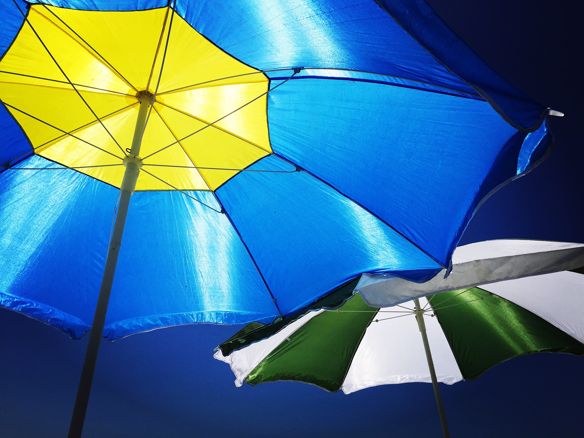 low angle view of colorful parasol against blue sky