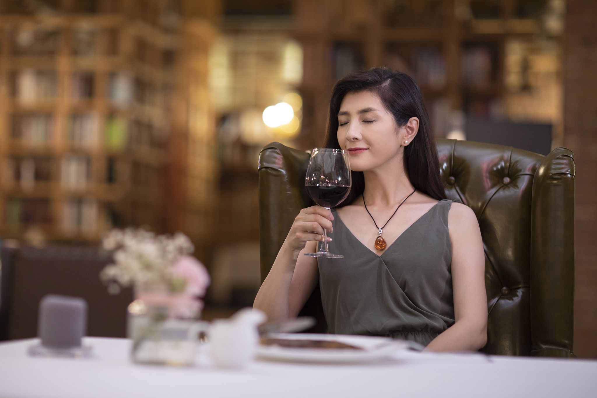 优雅女士在餐厅品尝红酒