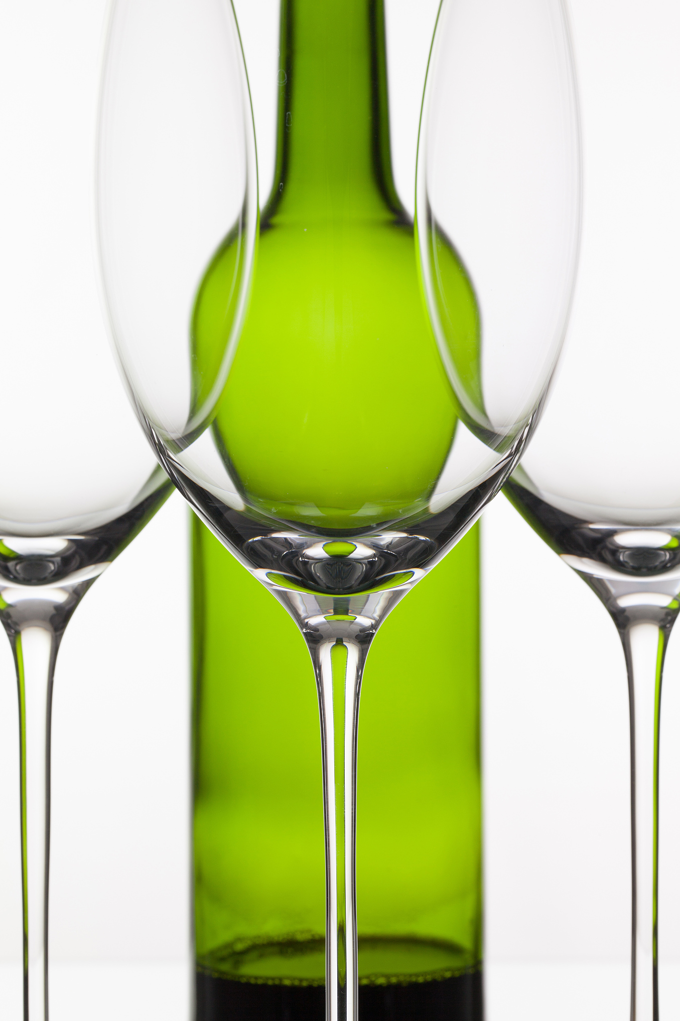 three empty glasses of wine and green bottle