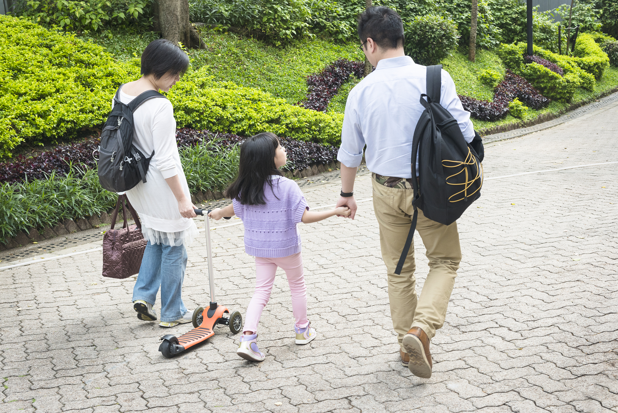 chinese family with push scooter in hong kong park, asia