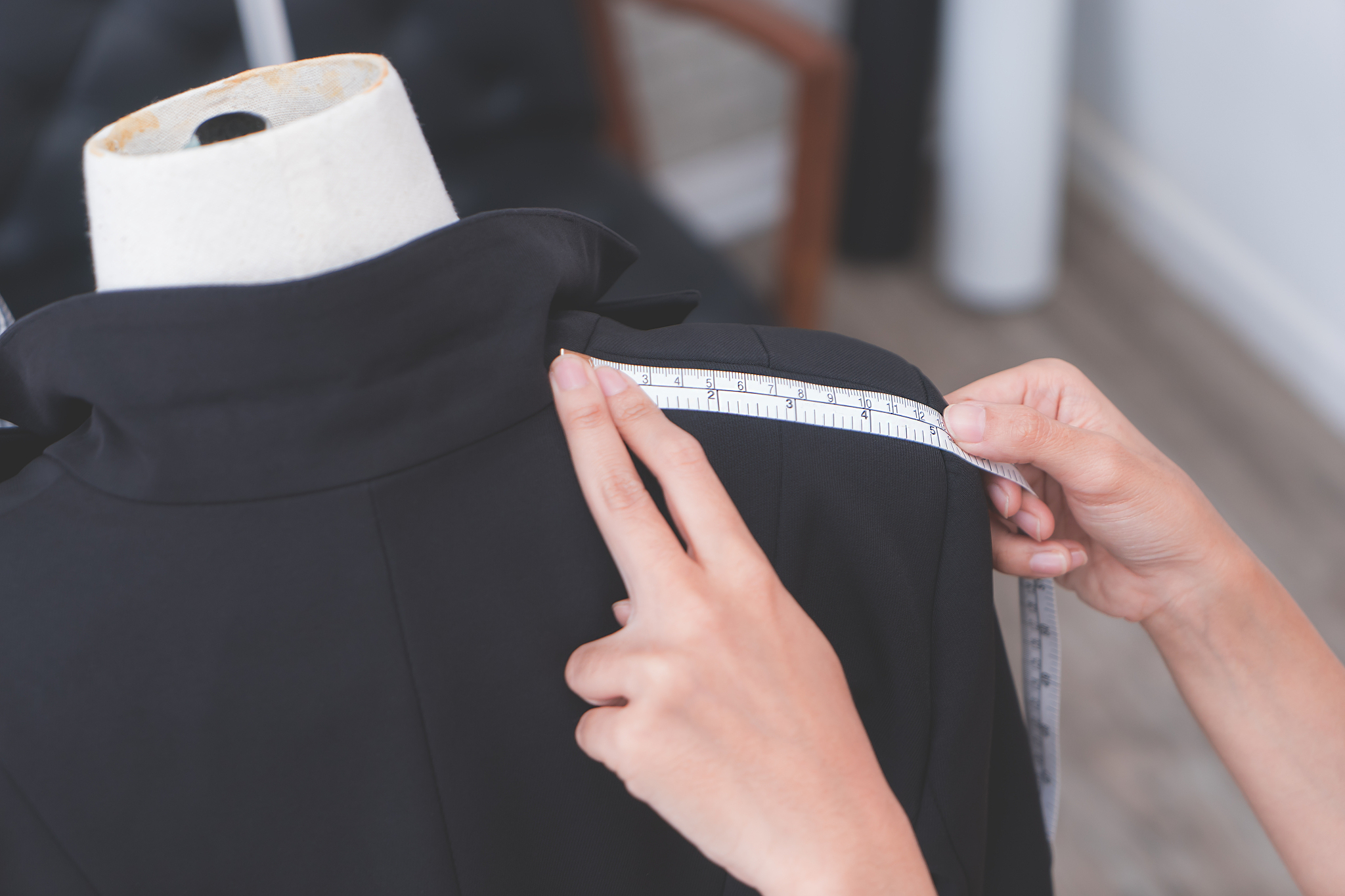fashion designer hand is measuring jacket shoulder