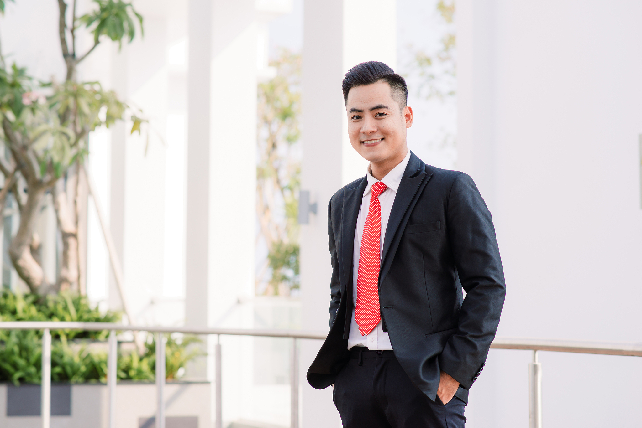 cheerful asian business man standing in park