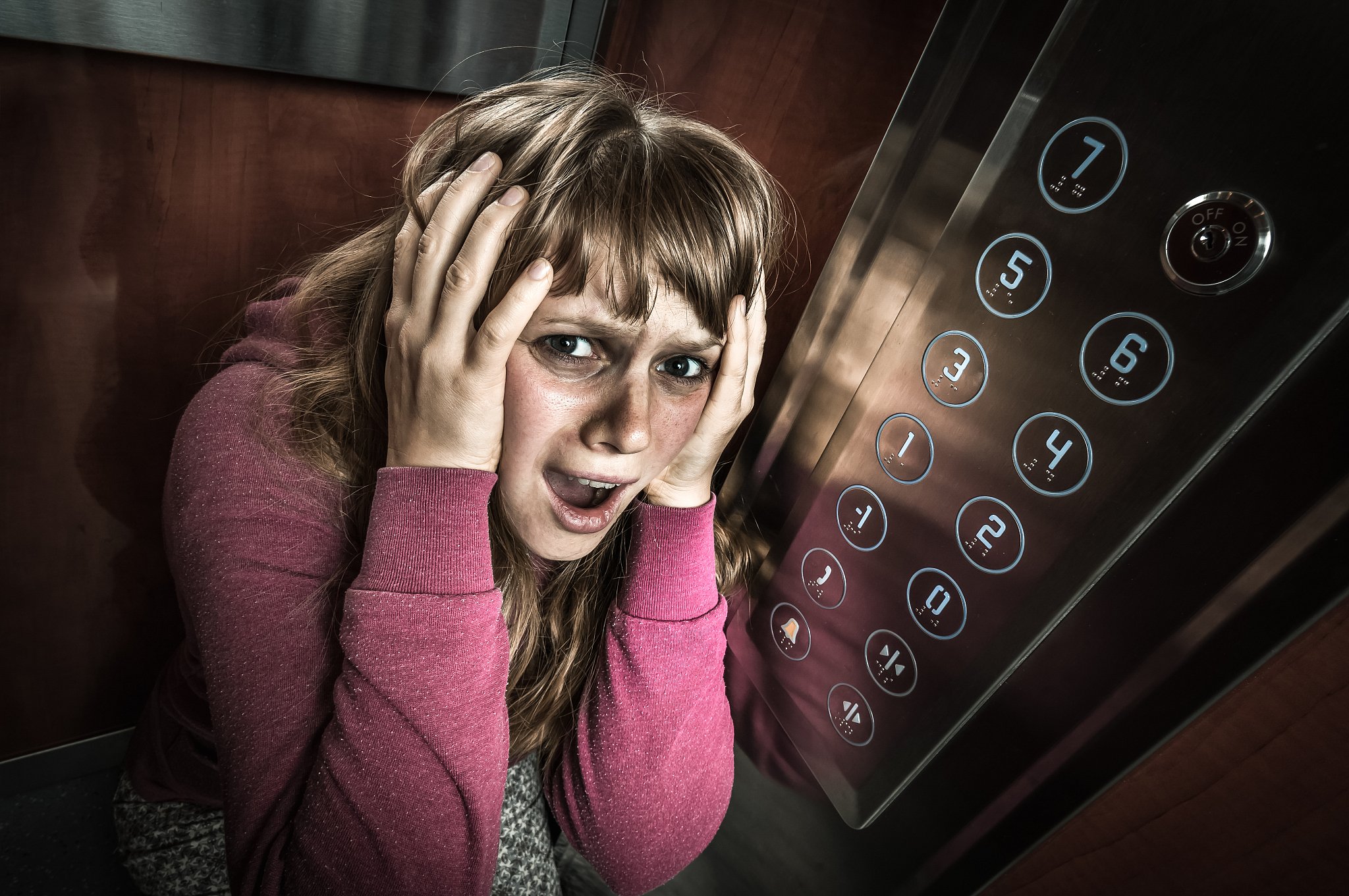 shocked woman with claustrophobia in the moving elevator