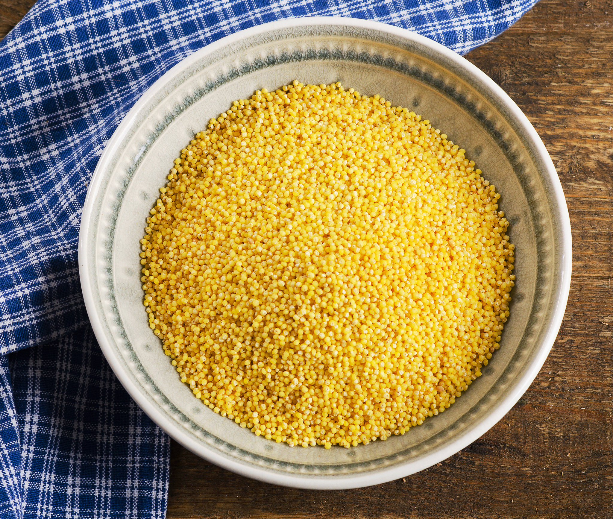 organic millet in bowl on a wooden rustic table.