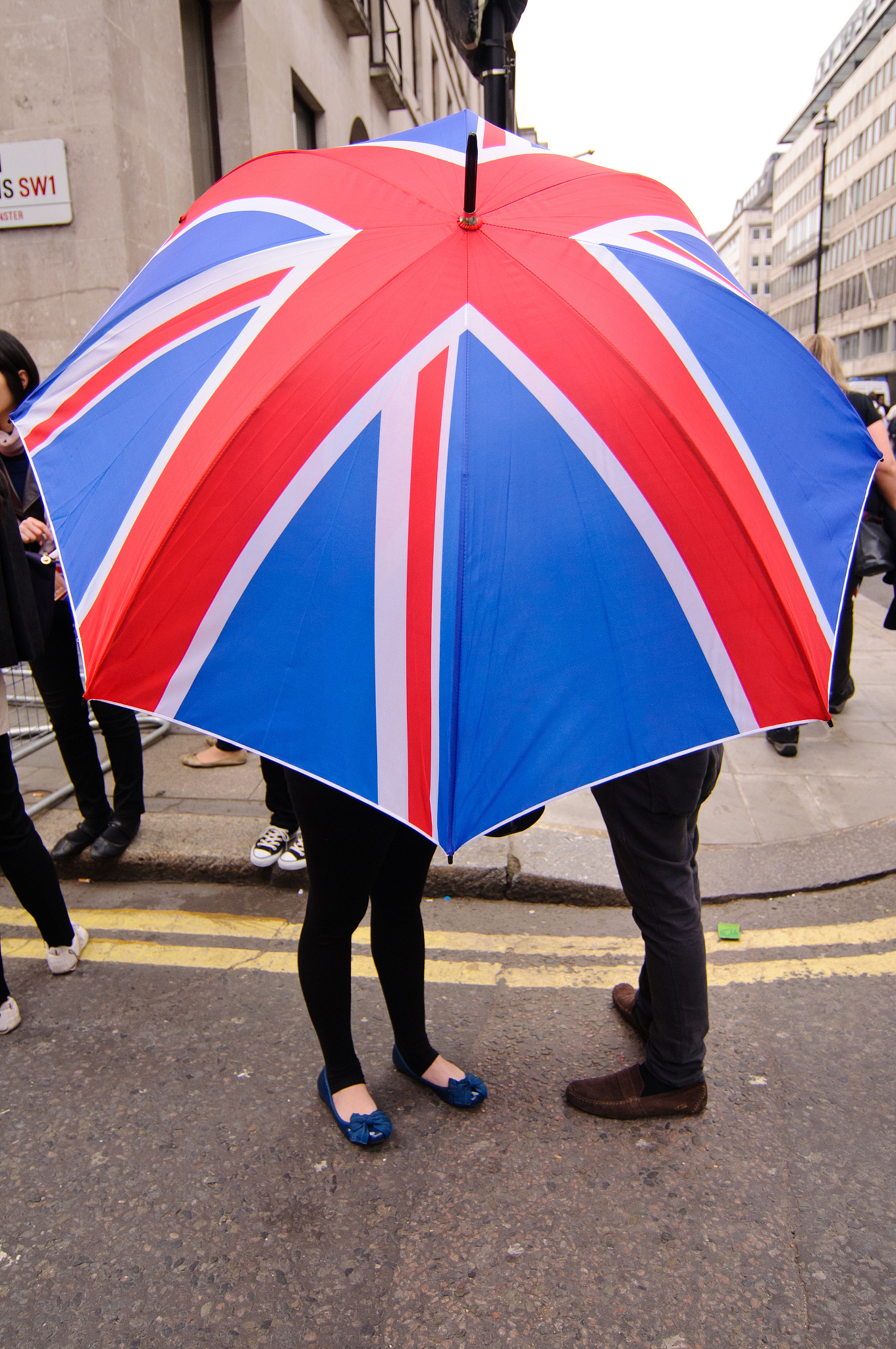 couple shelter under a union jack umbrella