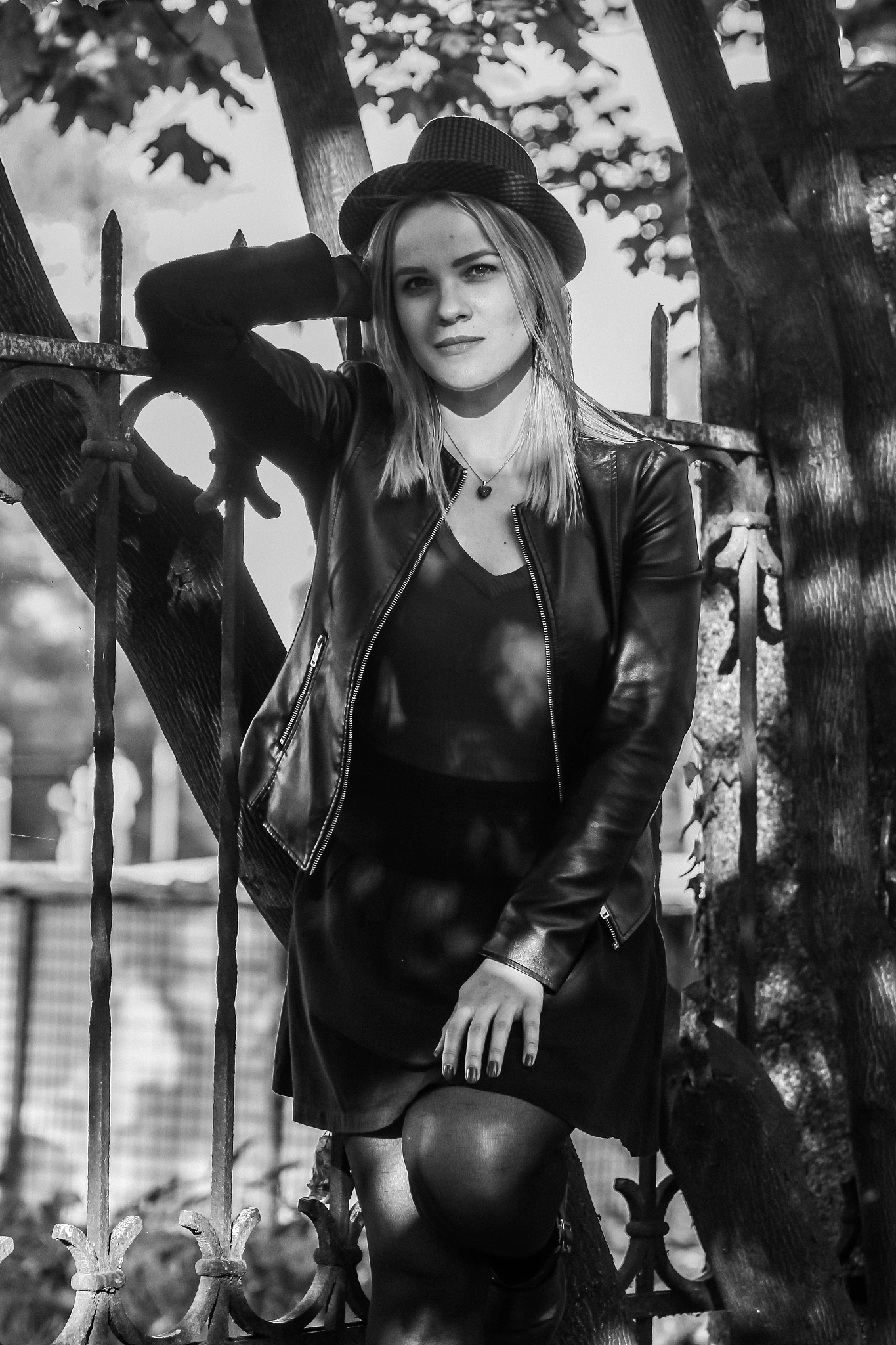 portrait of smiling young woman standing by tree at park