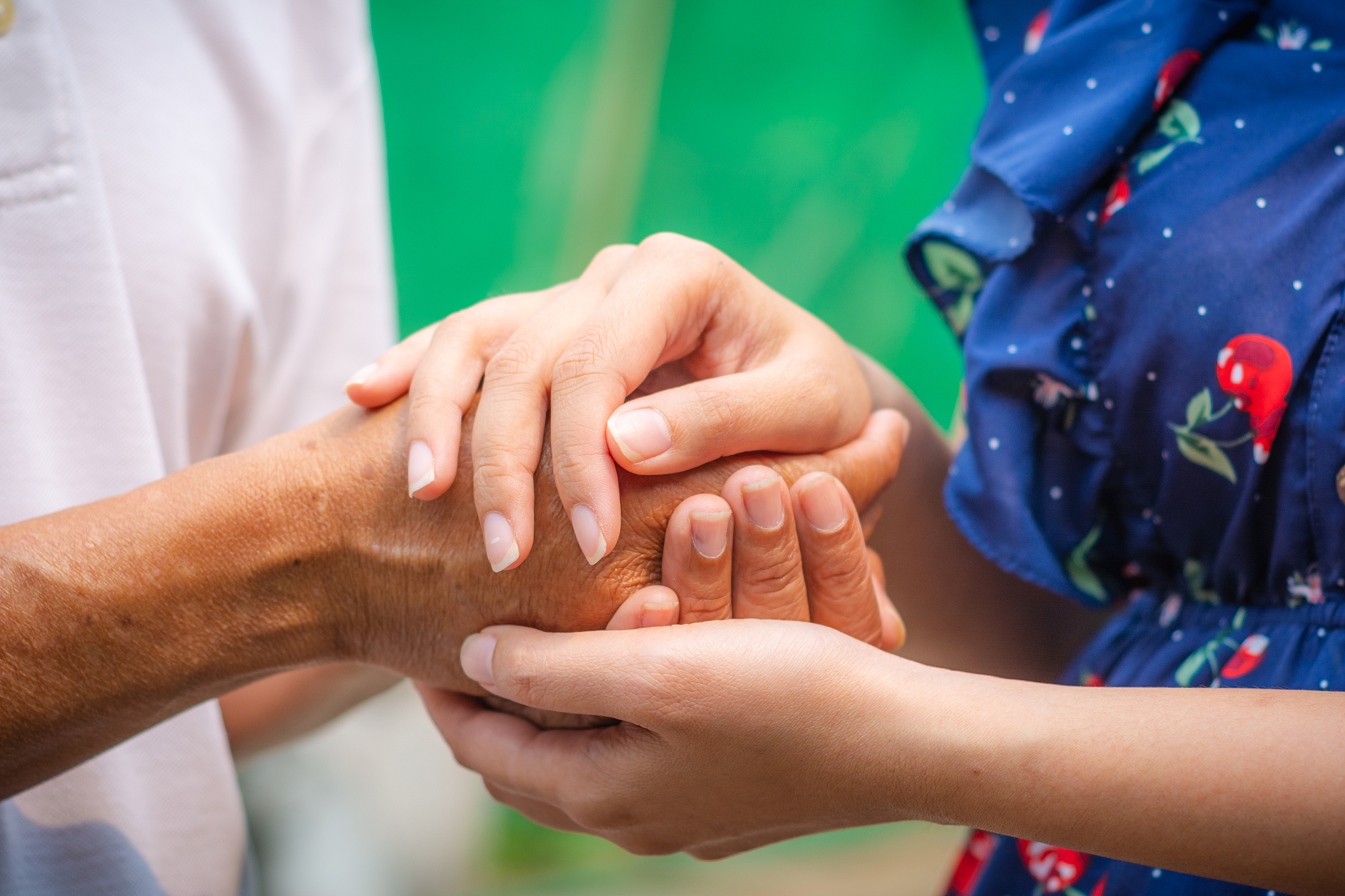 asian senior and asian young holding hands.