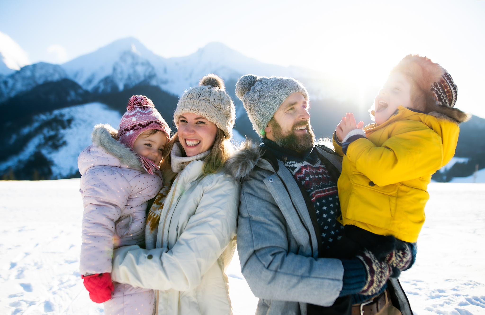 portrait of family with two small children enjoying snow in wint