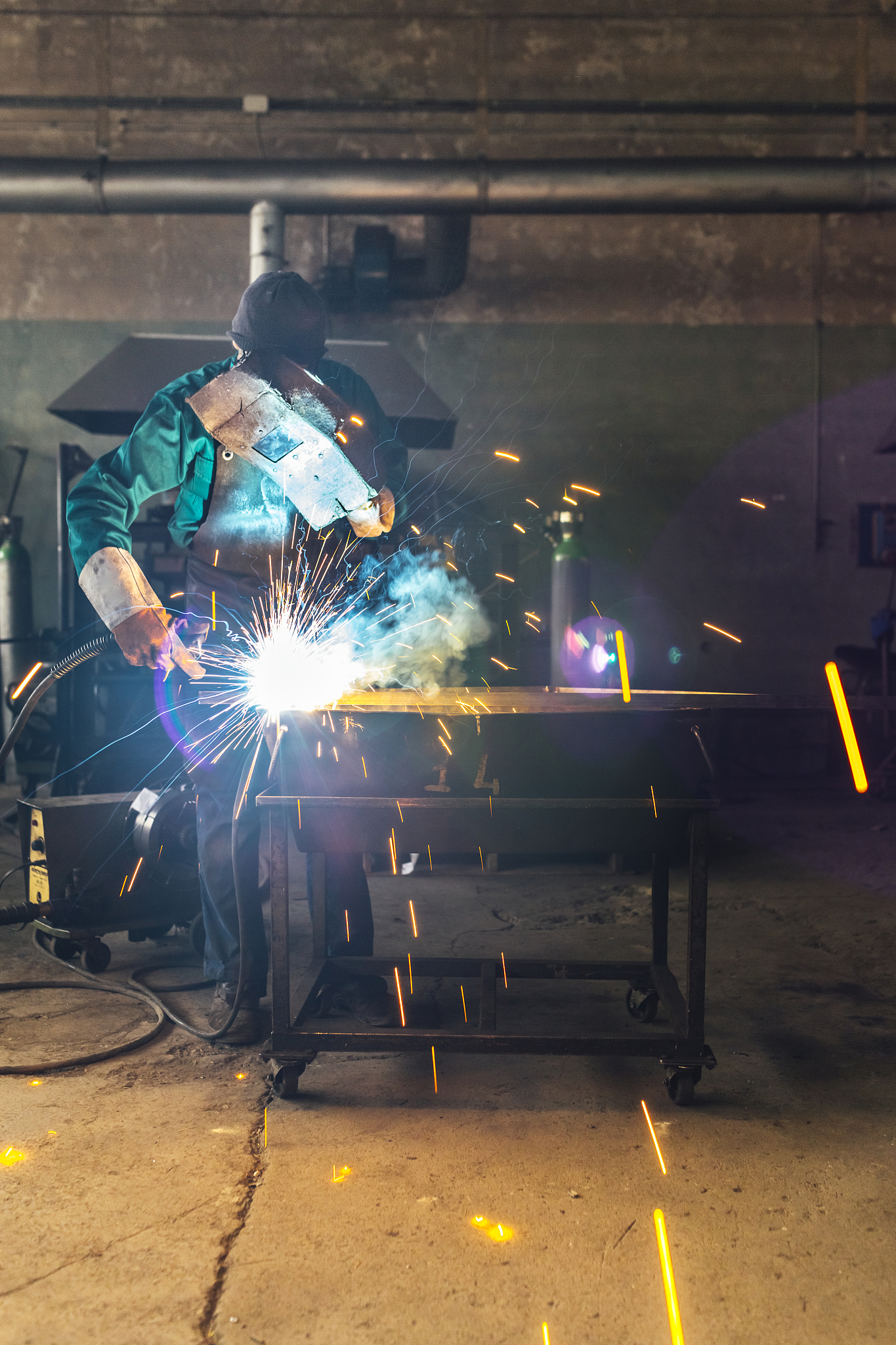 craftsman repairman is working with welding machine torch