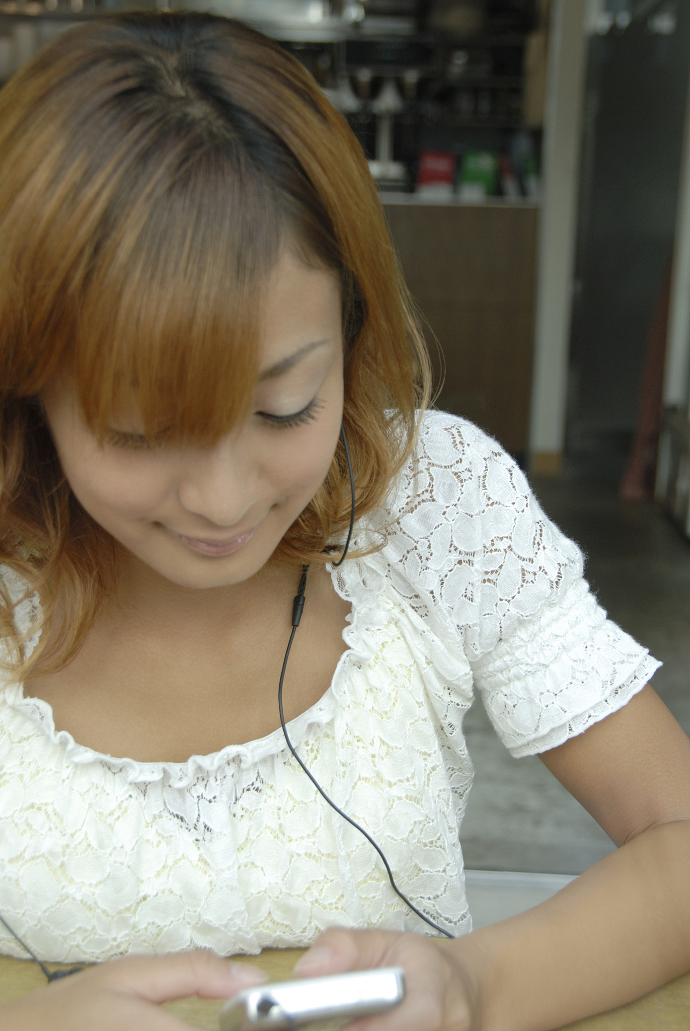 young woman listening to music in cafe, smiling
