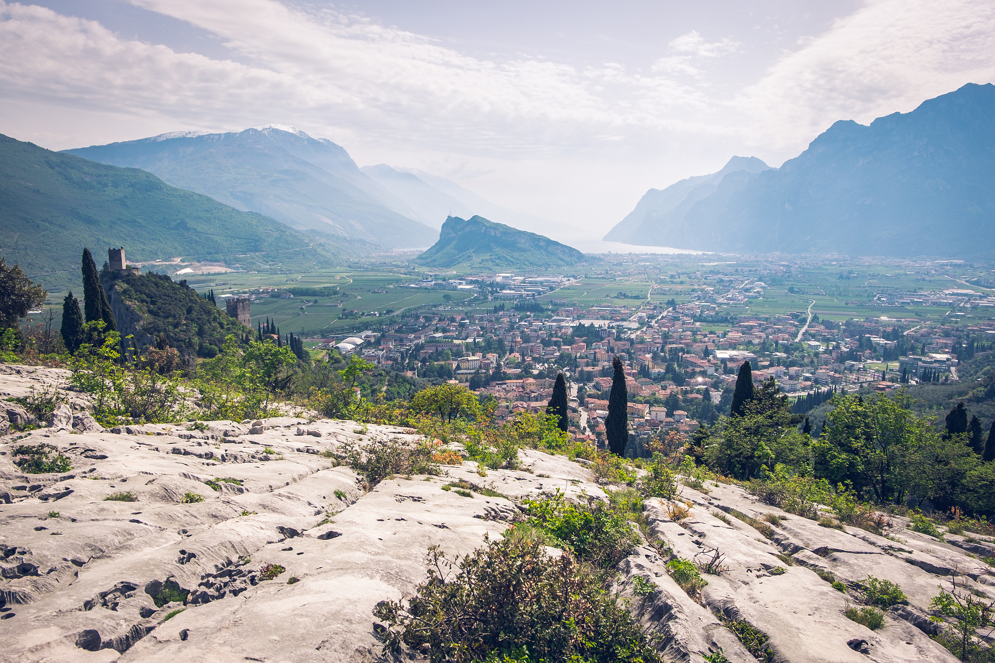 view of italian town arco, buildings and mountains. snow on the 