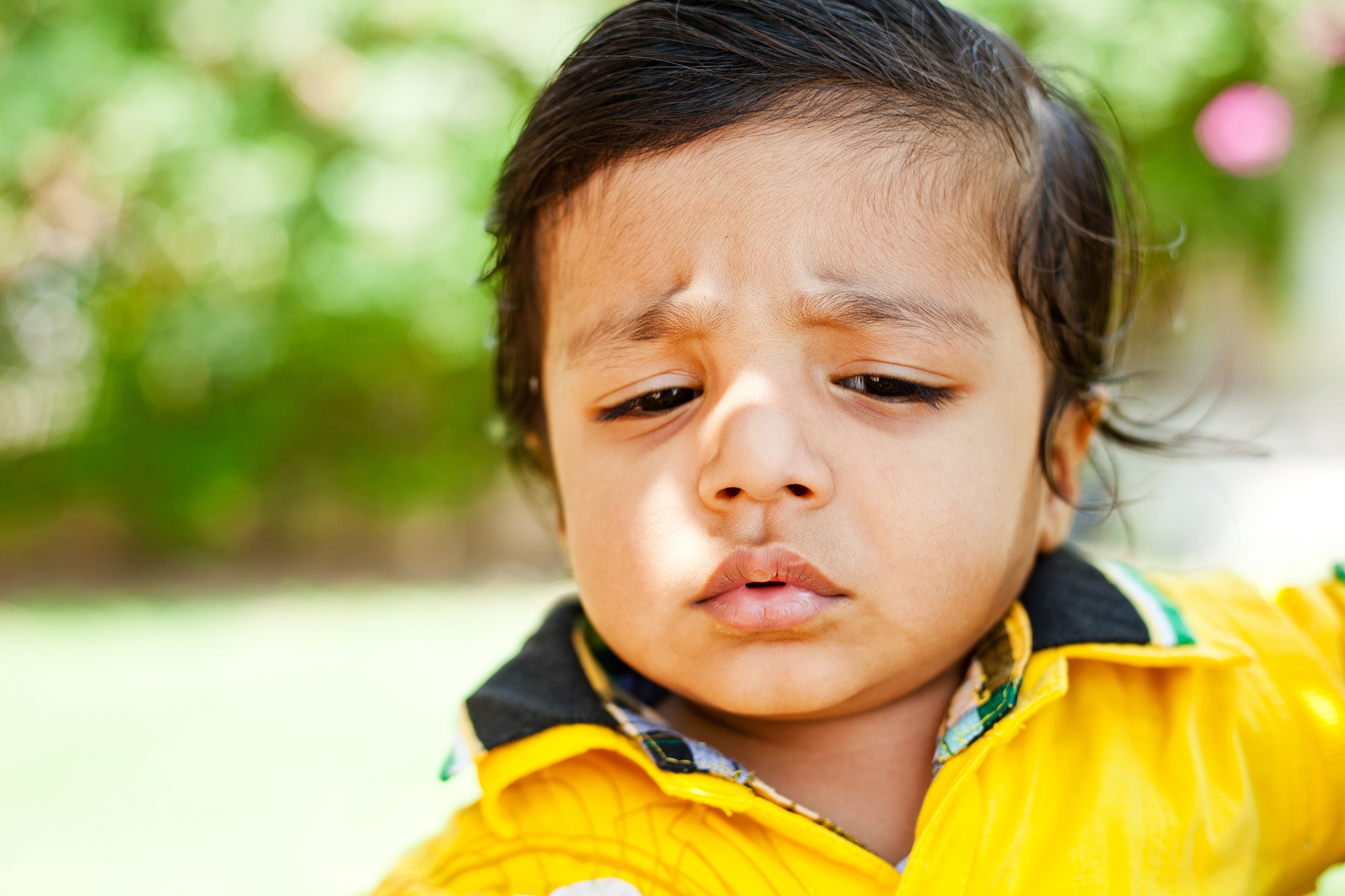 outdoor portrait of small annoyed indian boy child